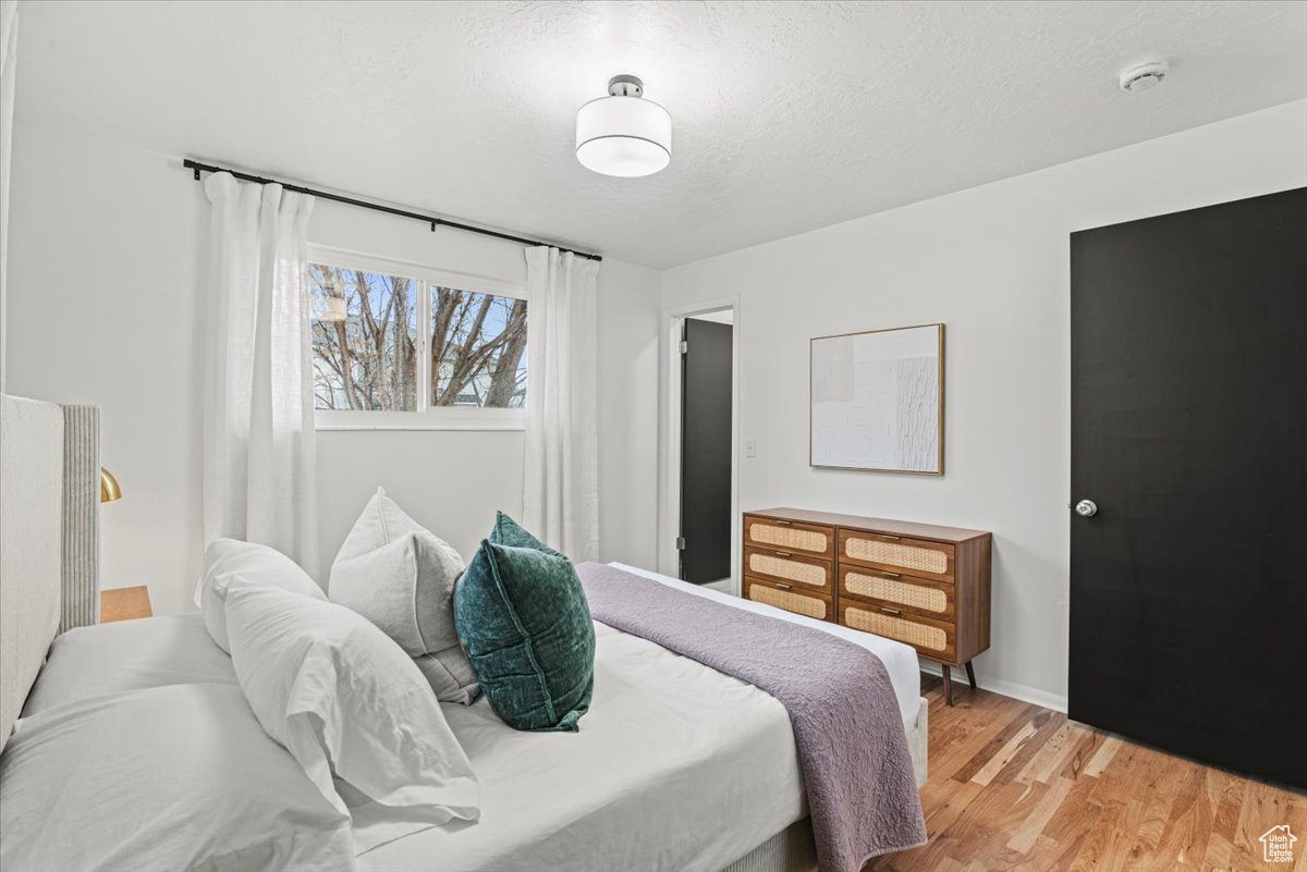 Bedroom with hardwood / wood flooring and a textured ceiling