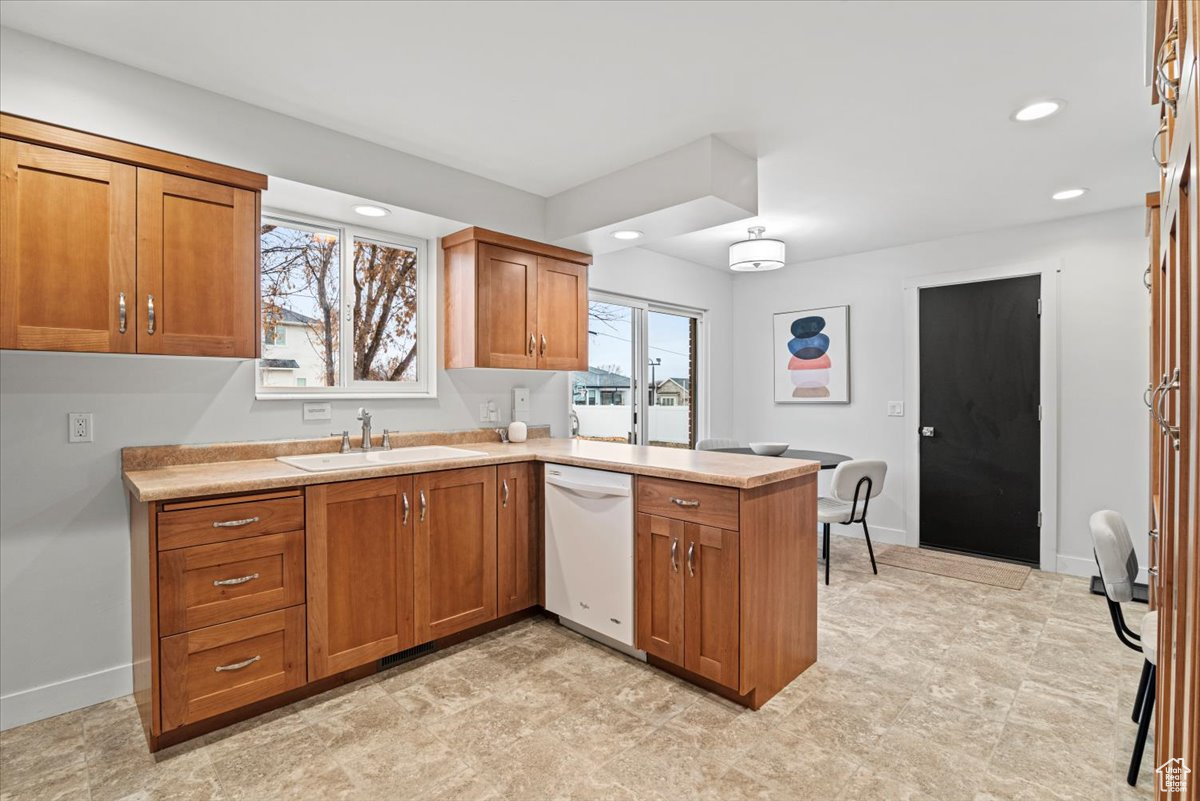 Kitchen with dishwasher, kitchen peninsula, and sink