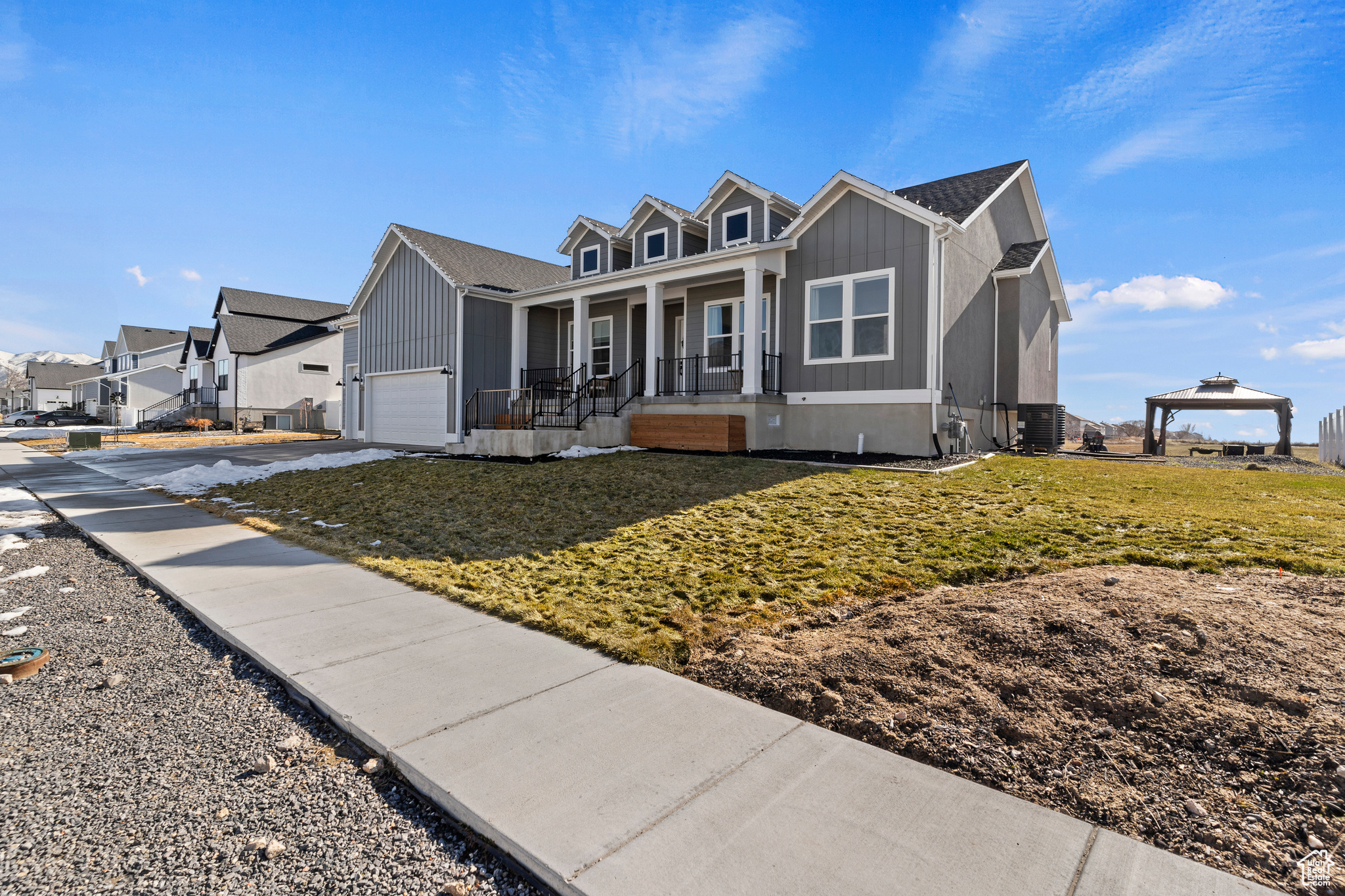 View of front of property featuring a front lawn, cooling unit, a gazebo, a porch, and a garage