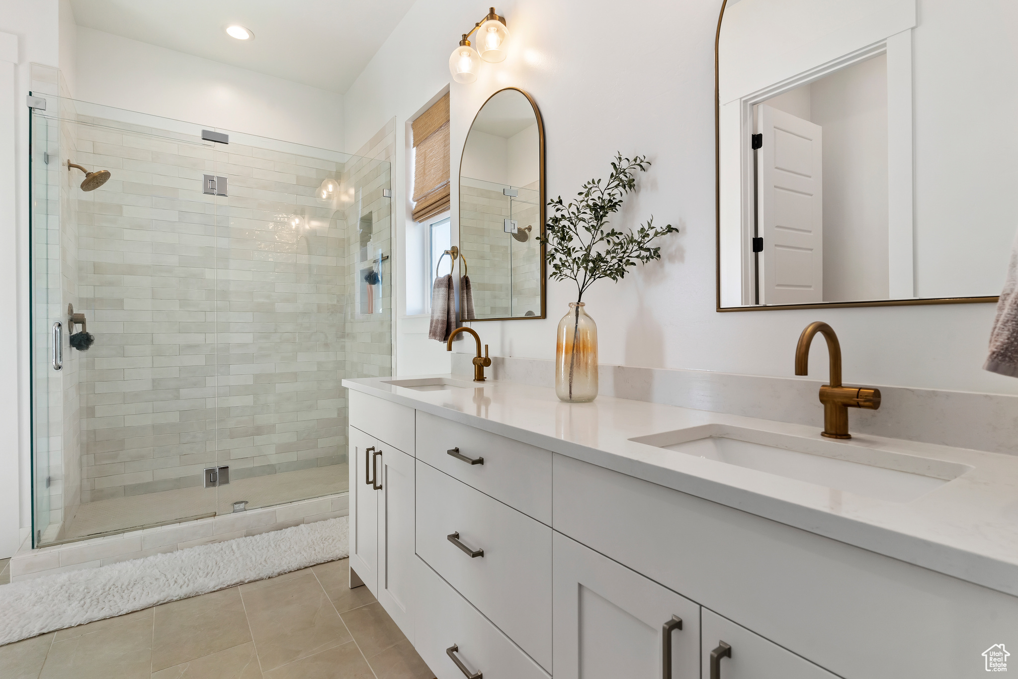 Bathroom with tile patterned floors, vanity, and a shower with shower door