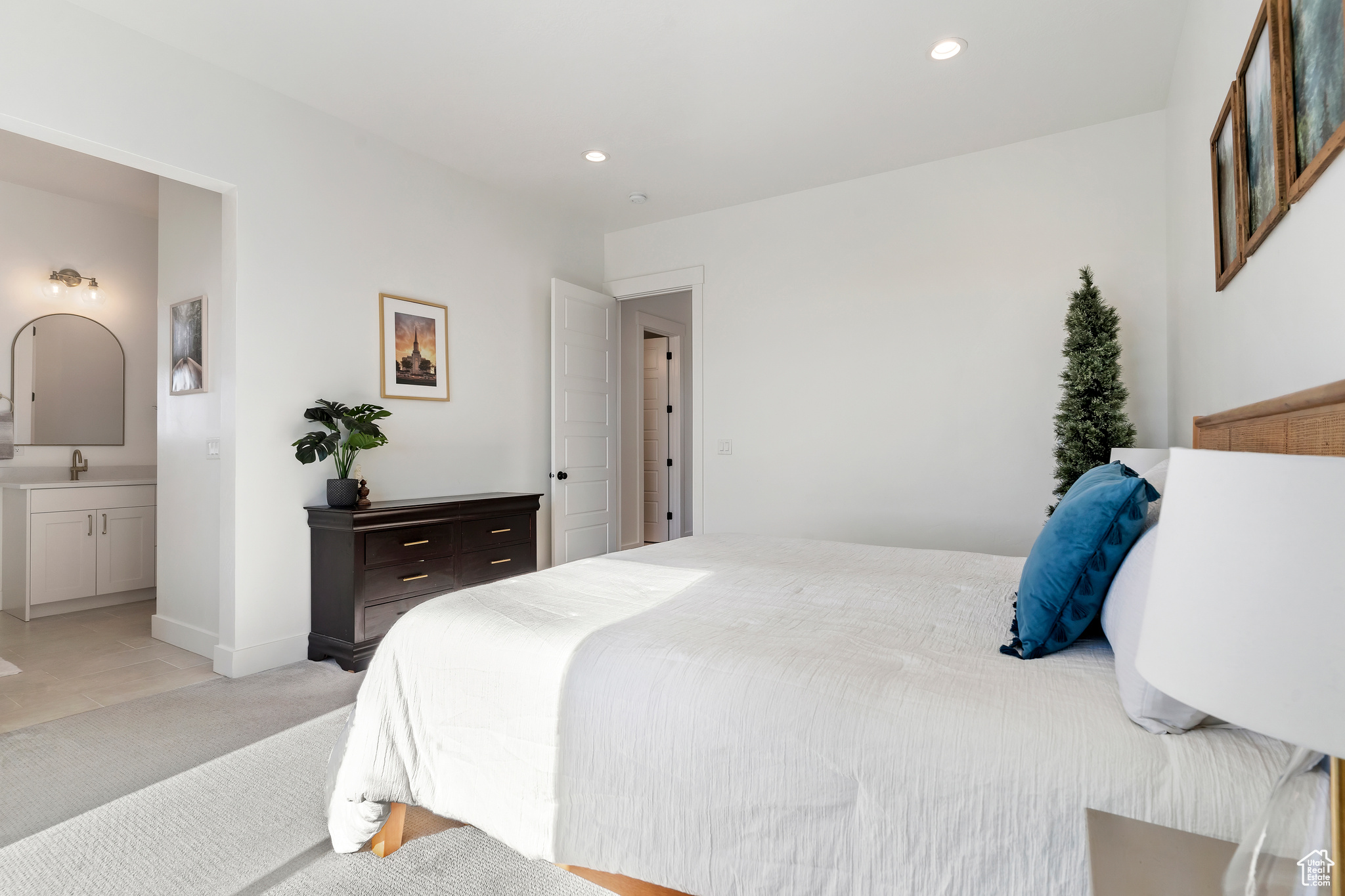 Carpeted bedroom with connected bathroom and sink