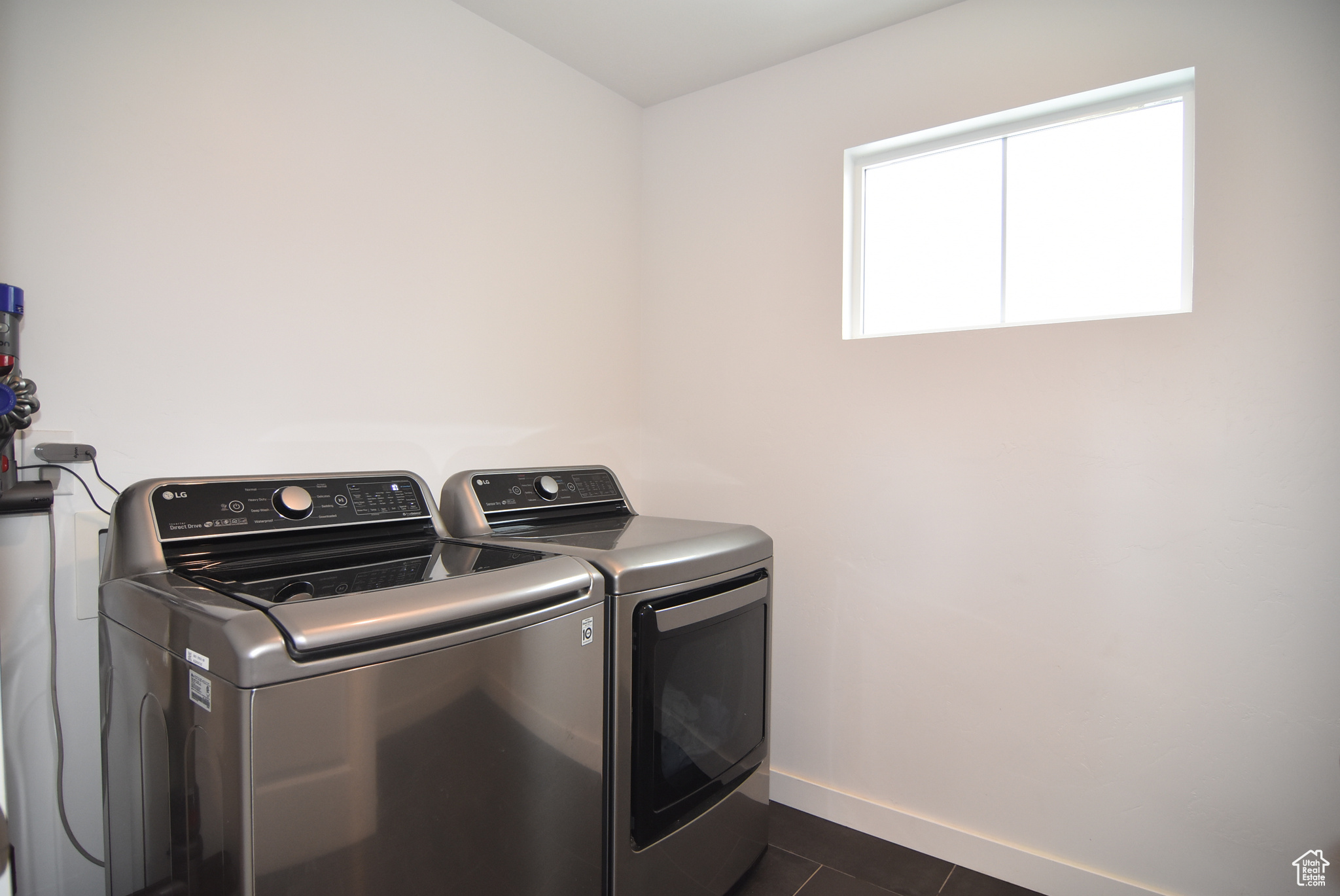 Laundry area  and dark tile patterned flooring