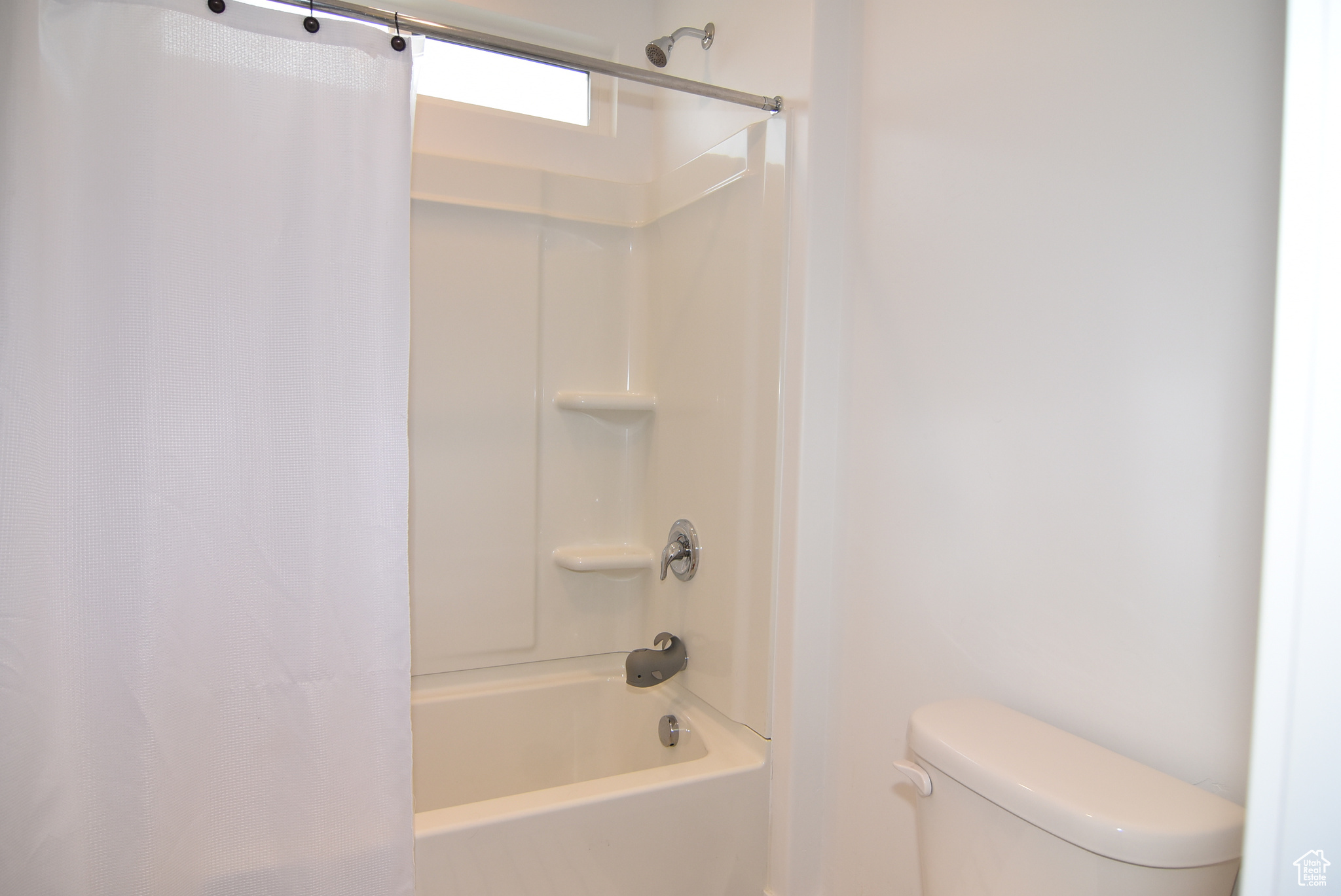 Bathroom featuring shower / tub combo and toilet