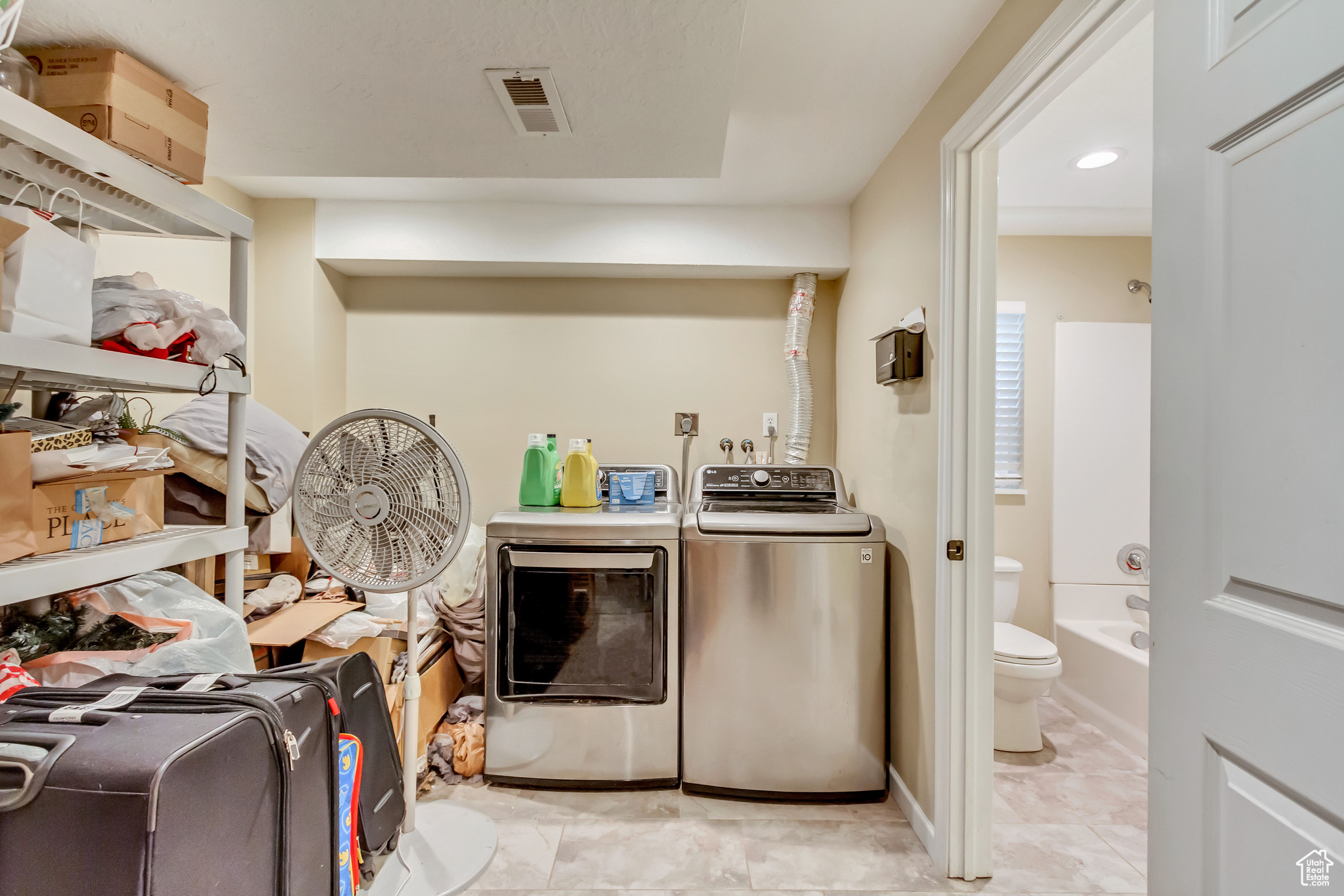 Laundry room with light tile patterned flooring and independent washer and dryer