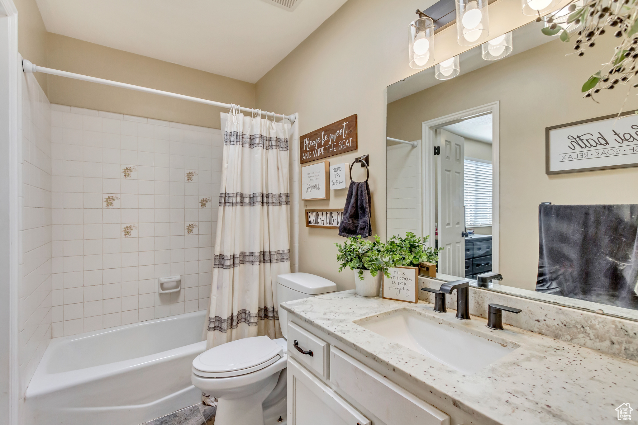 Full bathroom featuring vanity, toilet, and shower / tub combo