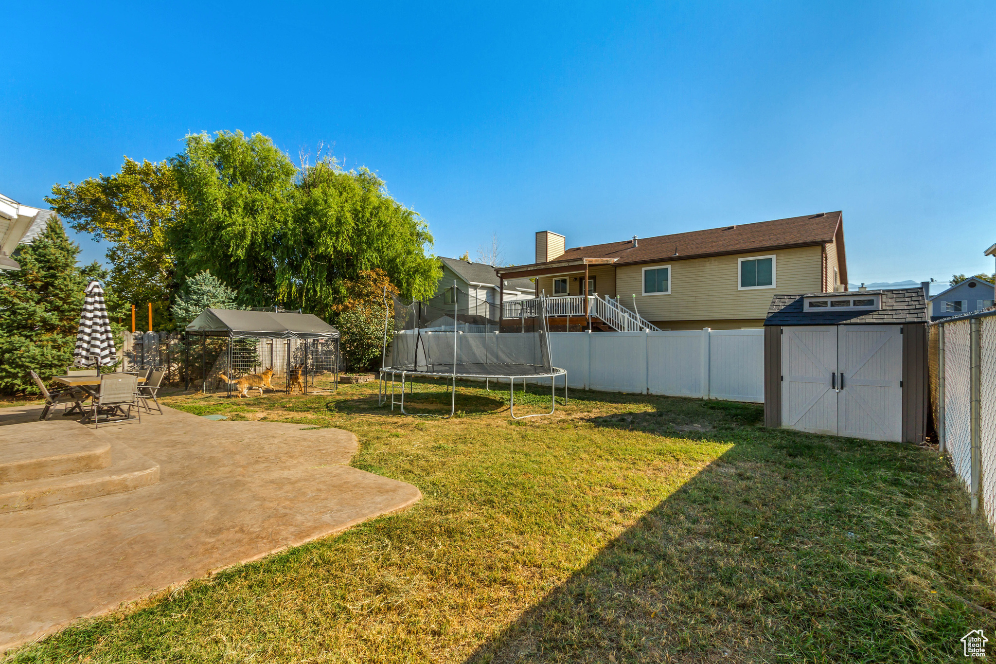 View of yard with a patio area, a shed, and a trampoline