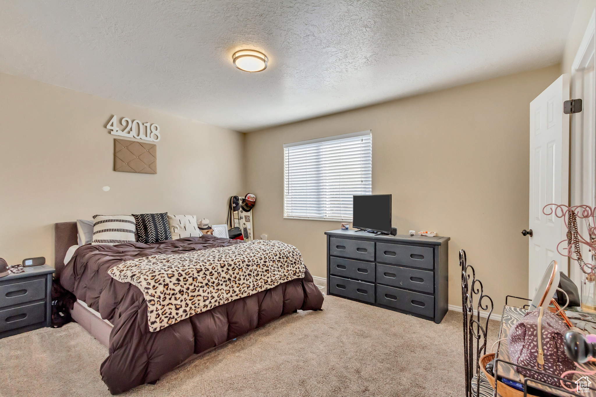 Bedroom with a textured ceiling and light carpet