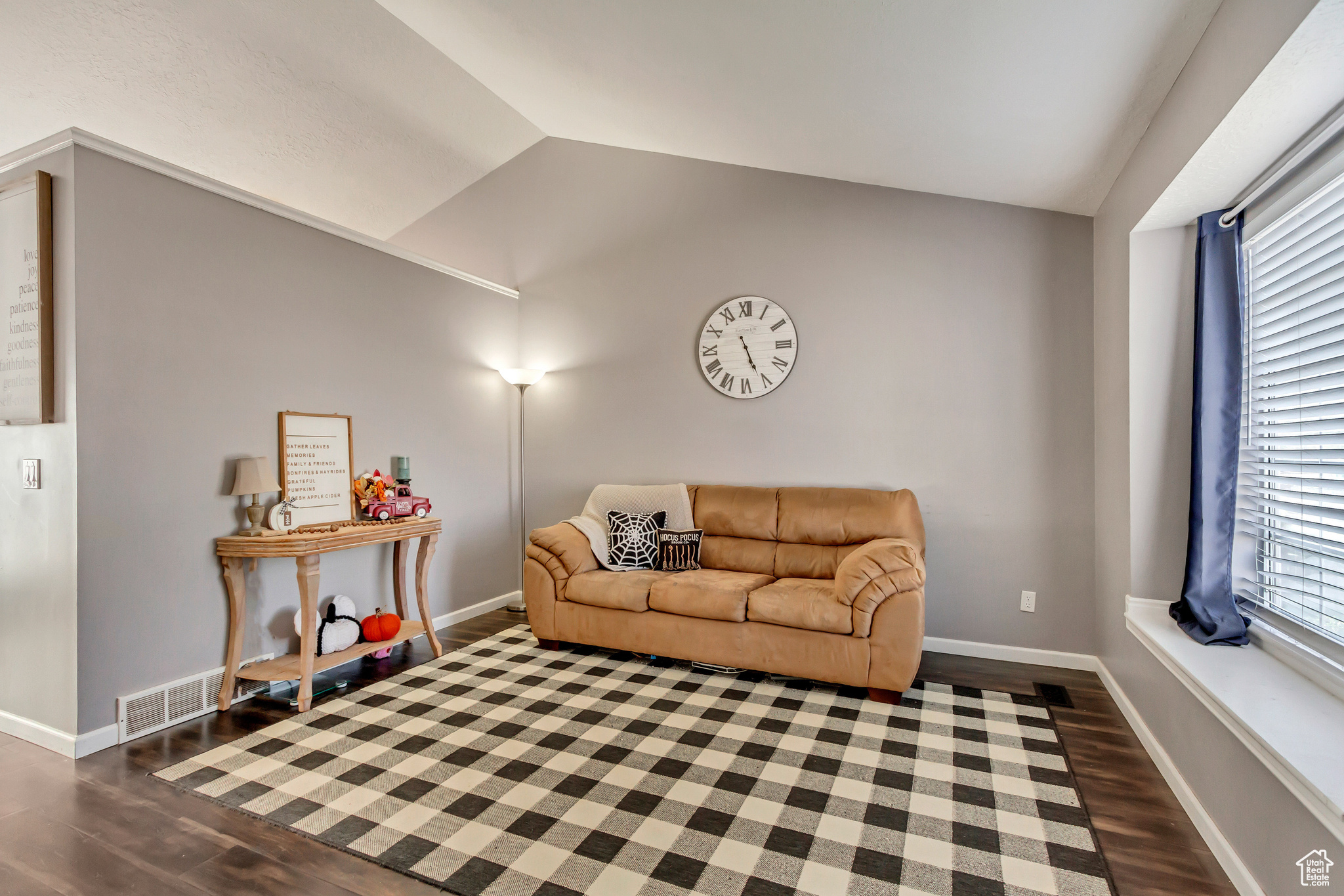 Living room with dark hardwood / wood-style flooring and lofted ceiling