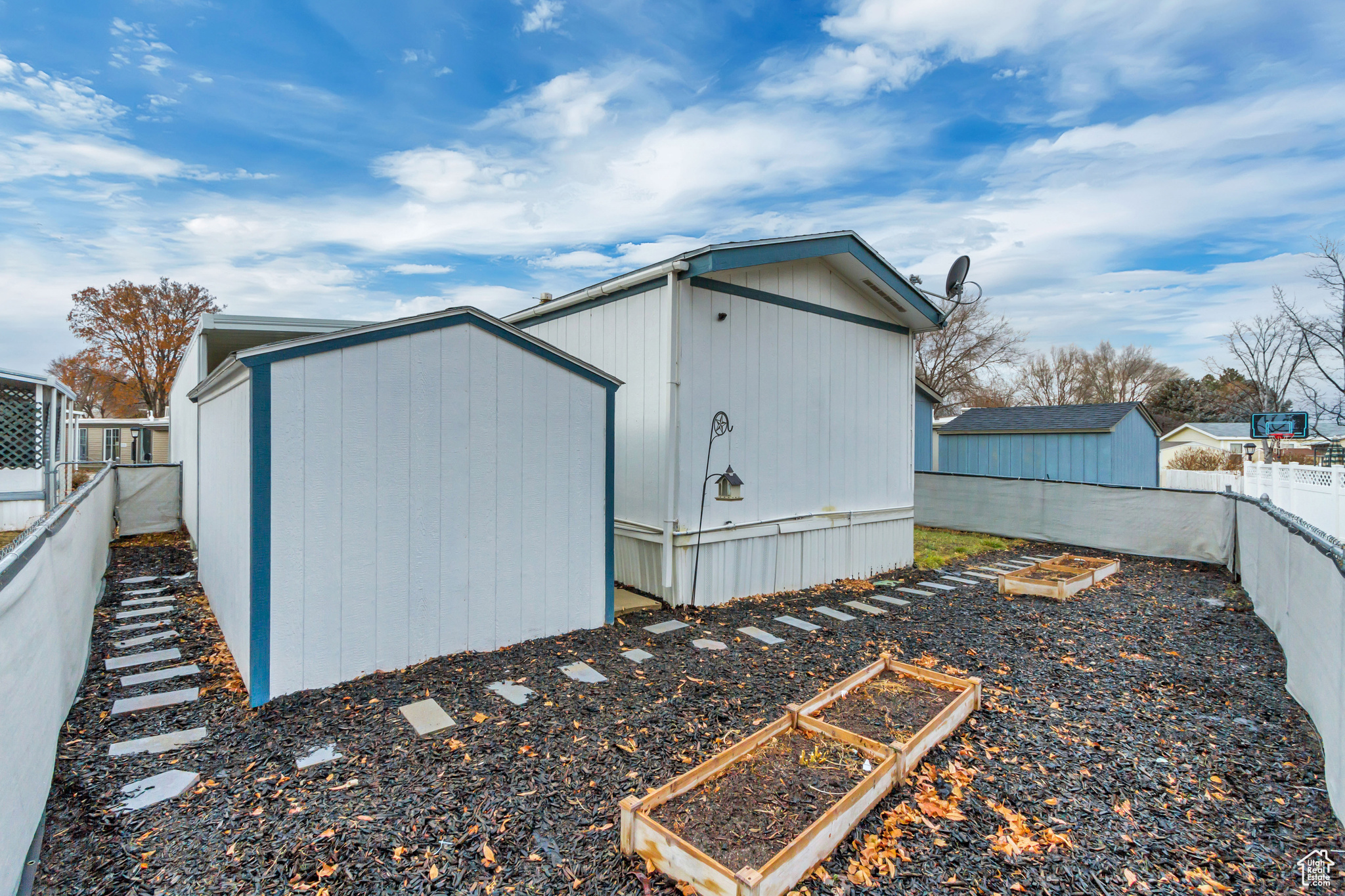 View of fully fenced backyard with planter boxes.