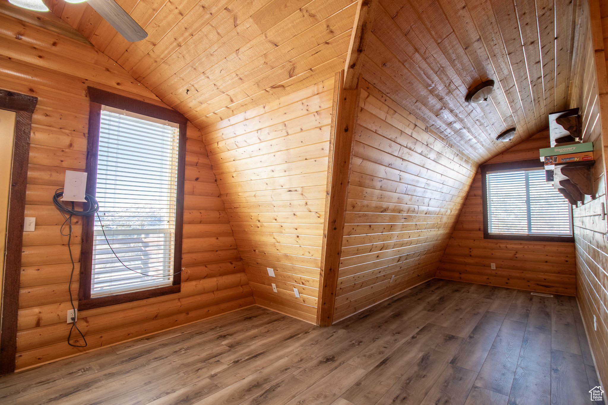 Bonus room with wood-type flooring, wooden ceiling, rustic walls, and vaulted ceiling