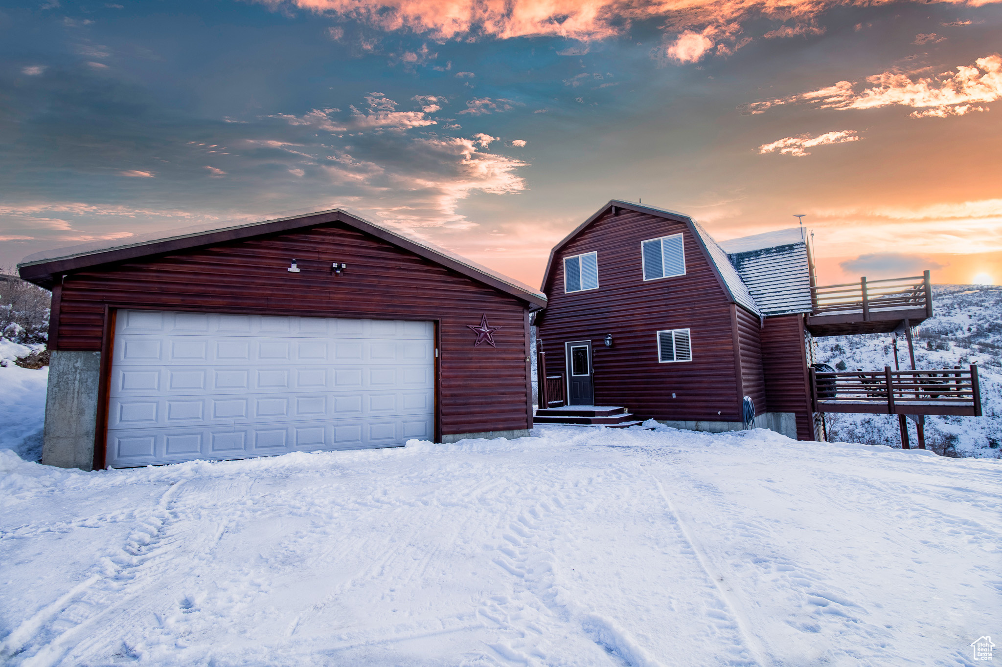 View of front of property featuring an outbuilding, a balcony, and a garage