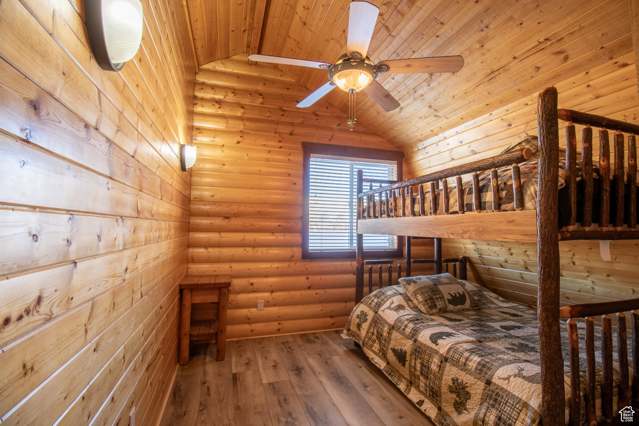 Bedroom featuring wood ceiling, ceiling fan, log walls, hardwood / wood-style floors, and lofted ceiling