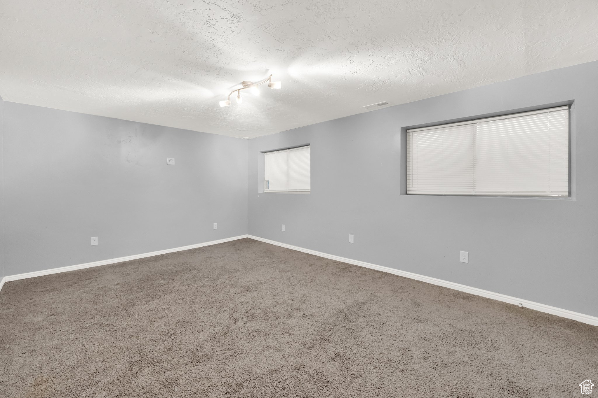 Unfurnished room featuring carpet and a textured ceiling