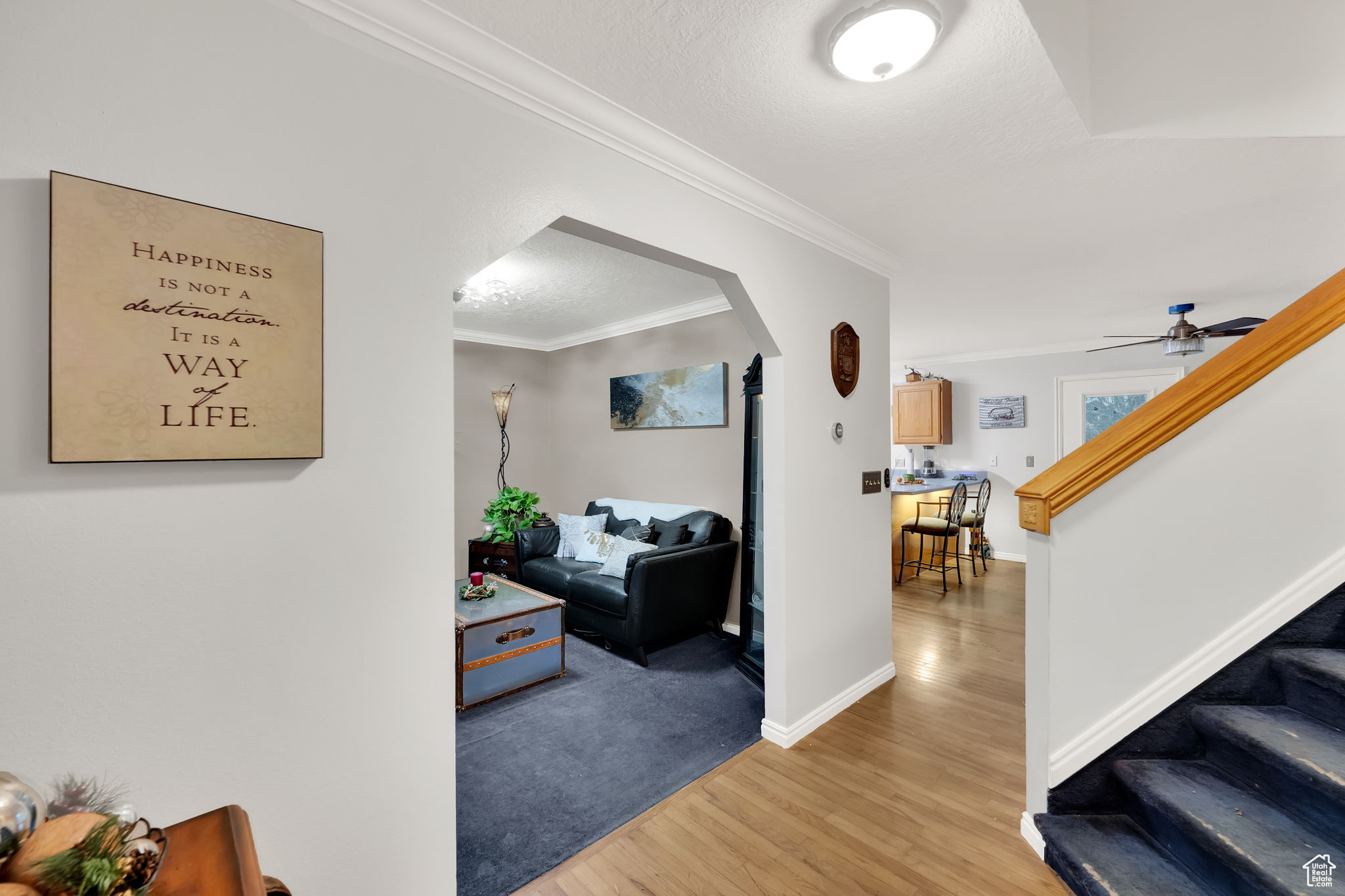 Hallway with a textured ceiling, light hardwood / wood-style flooring, and ornamental molding