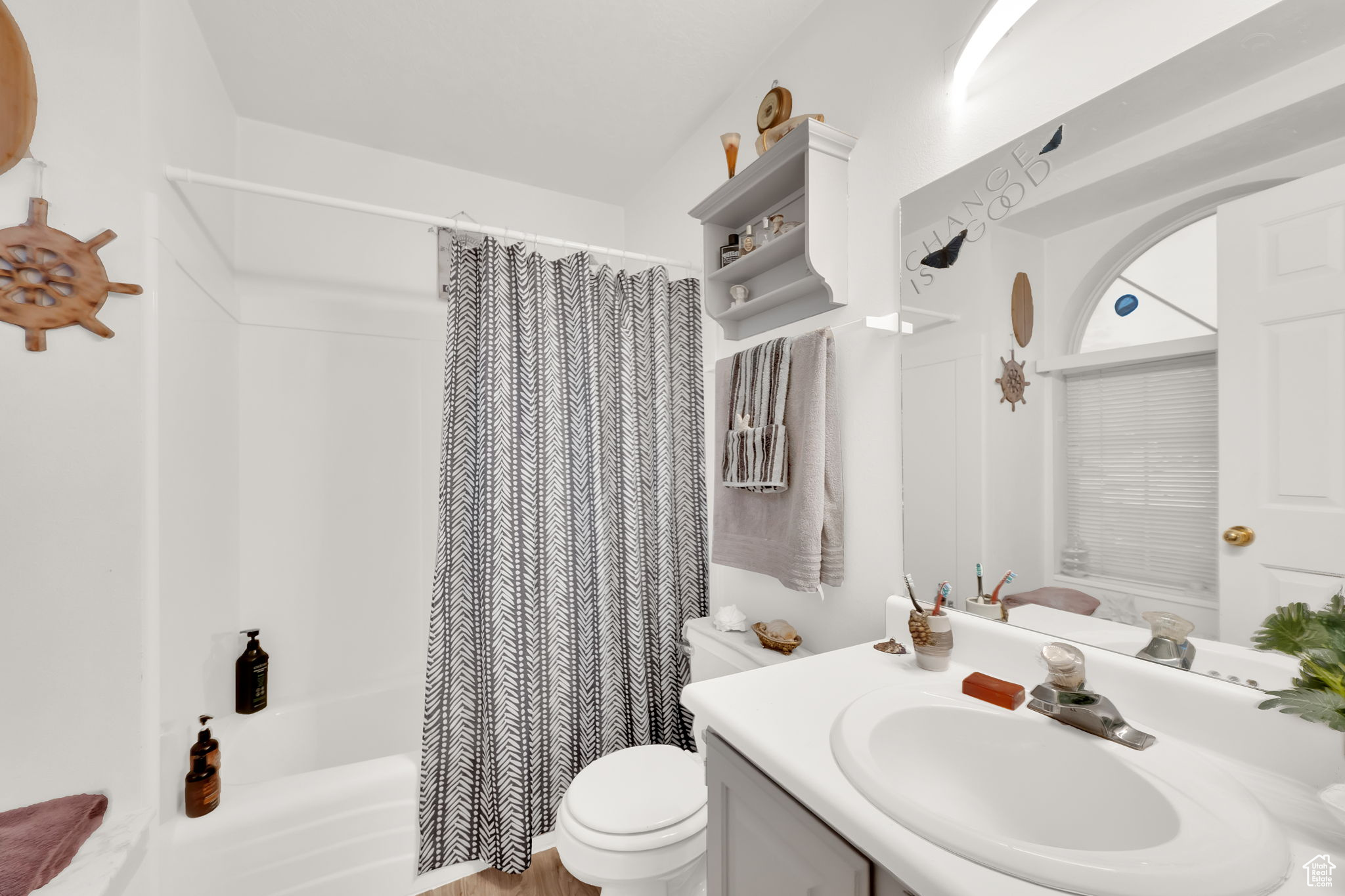 Full bathroom featuring shower / bath combo with shower curtain, vanity, and toilet