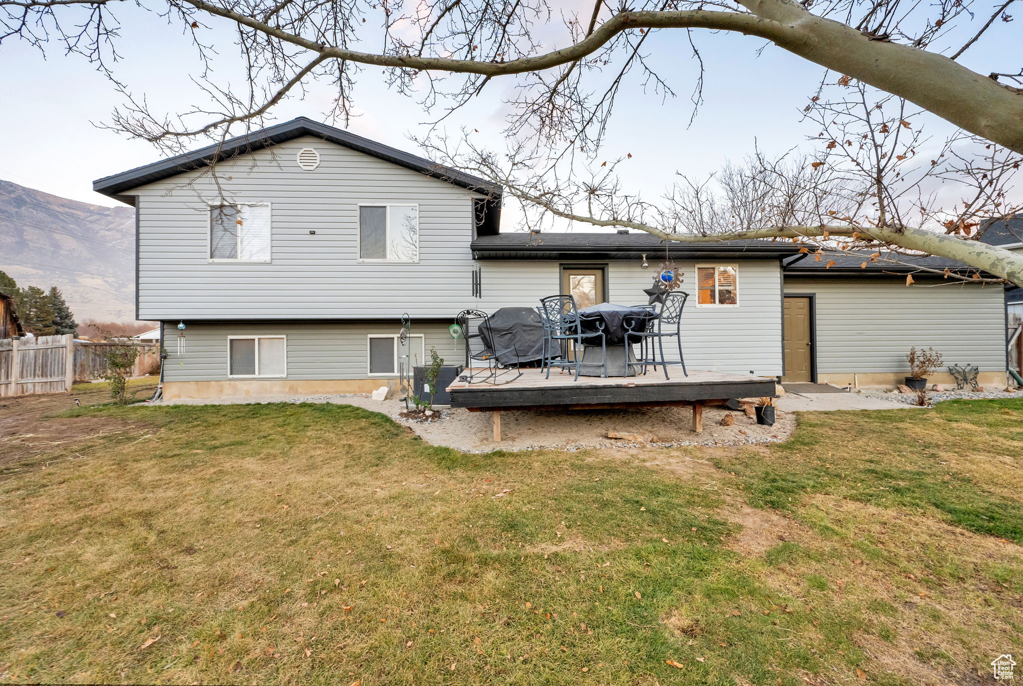 Rear view of property featuring a deck with mountain view and a lawn