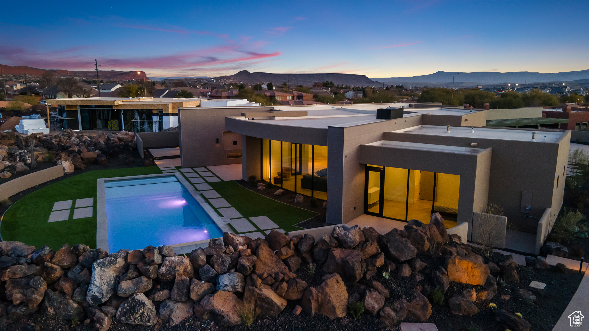 Back house at dusk featuring a patio area and a mountain view