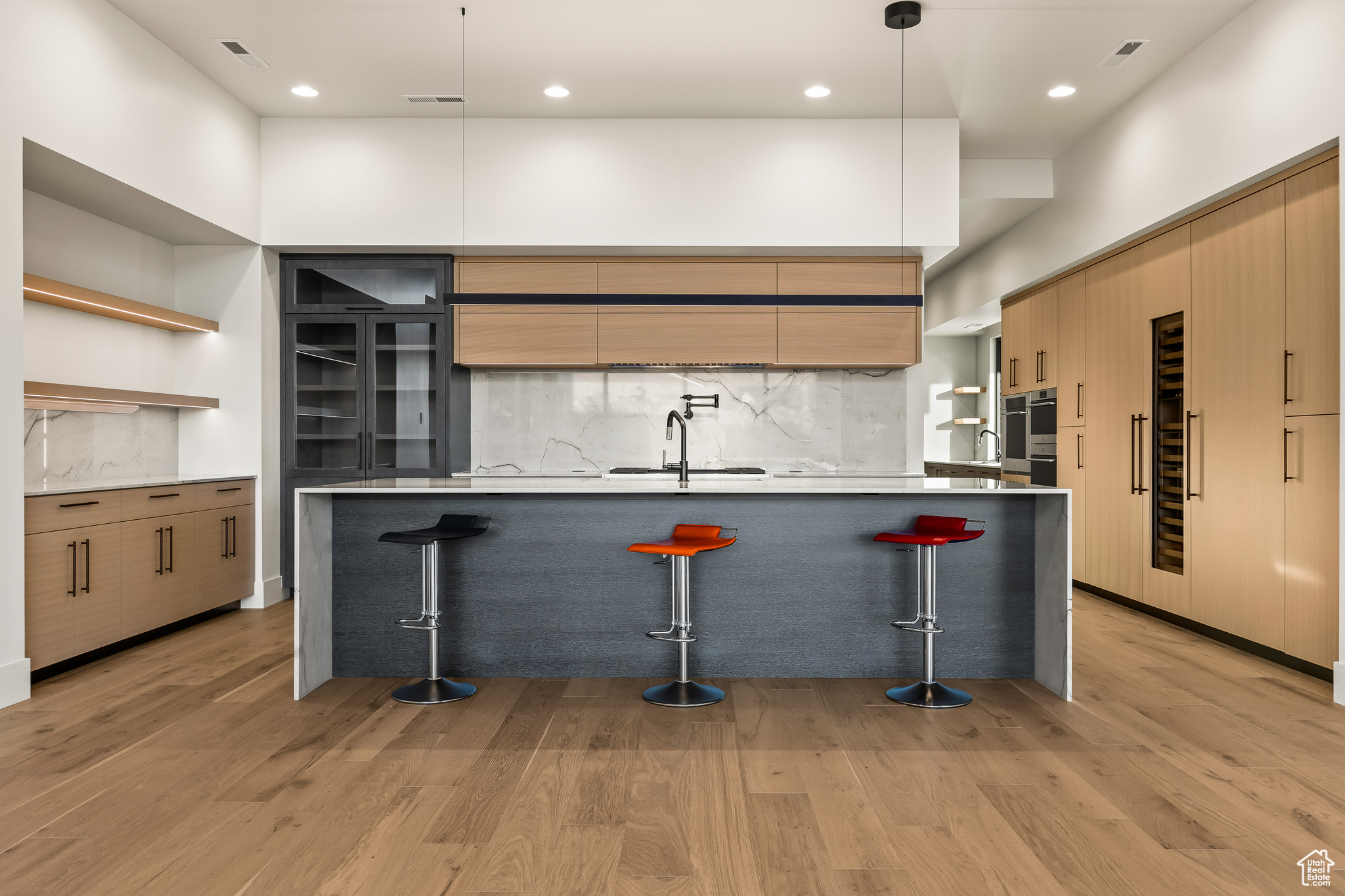 Kitchen with backsplash, sink, a kitchen bar, and decorative light fixtures