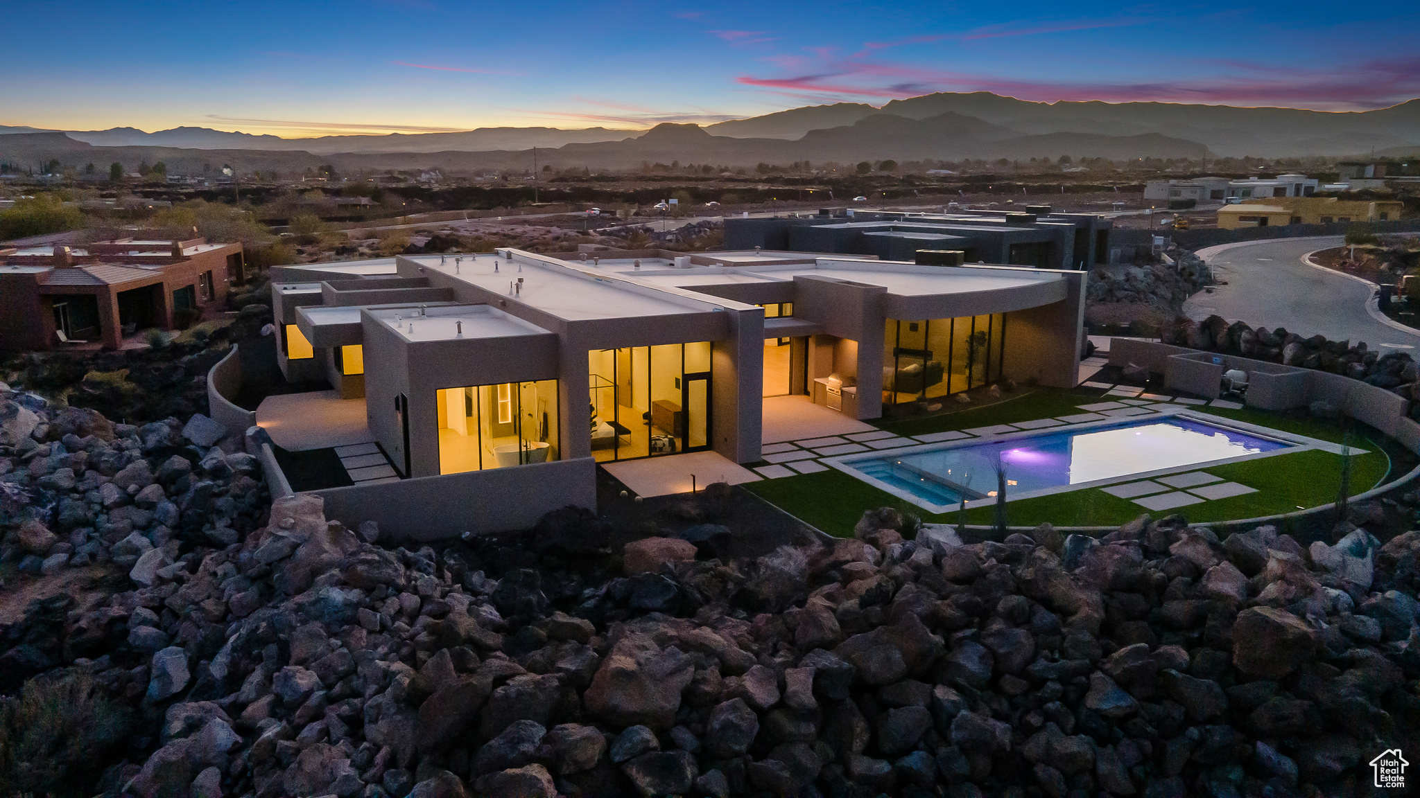 Back house at dusk with a mountain view and a patio