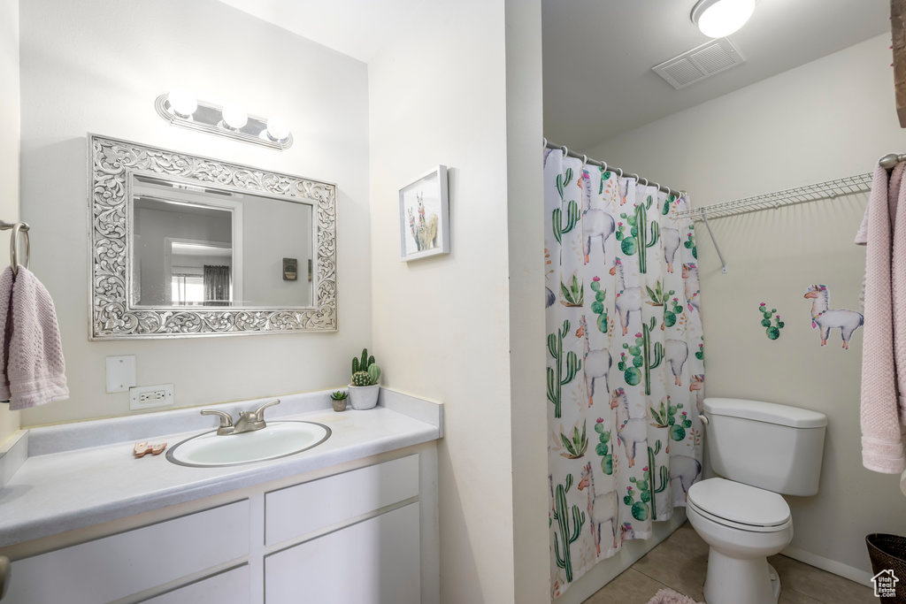 Bathroom featuring tile patterned flooring, vanity, toilet, and a shower with shower curtain