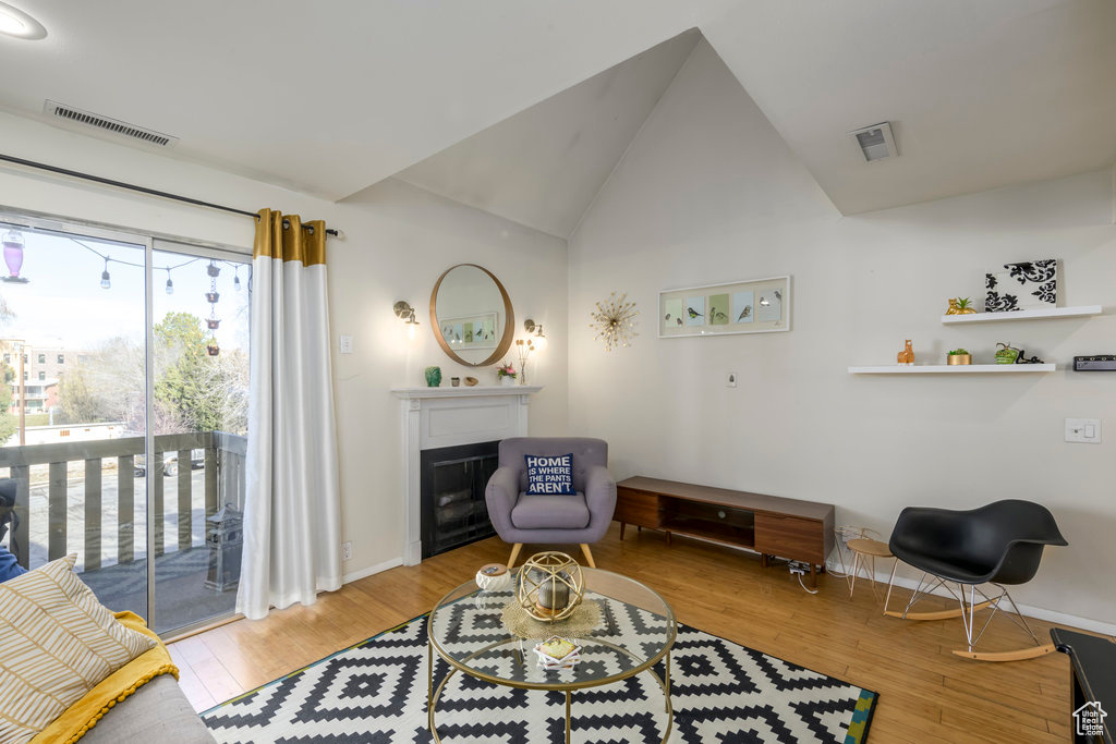 Living area featuring vaulted ceiling and light hardwood / wood-style flooring