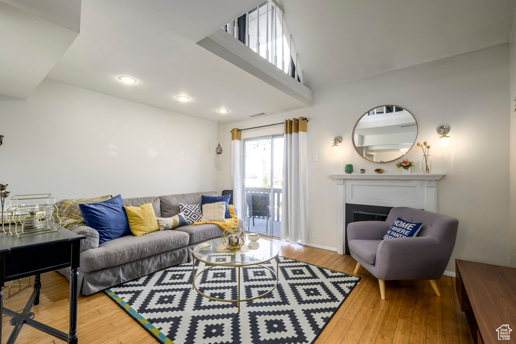 Living room with hardwood / wood-style floors and high vaulted ceiling