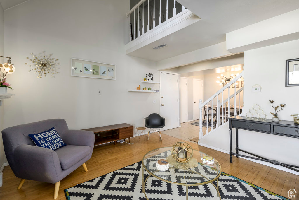 Living room with wood-type flooring and a notable chandelier