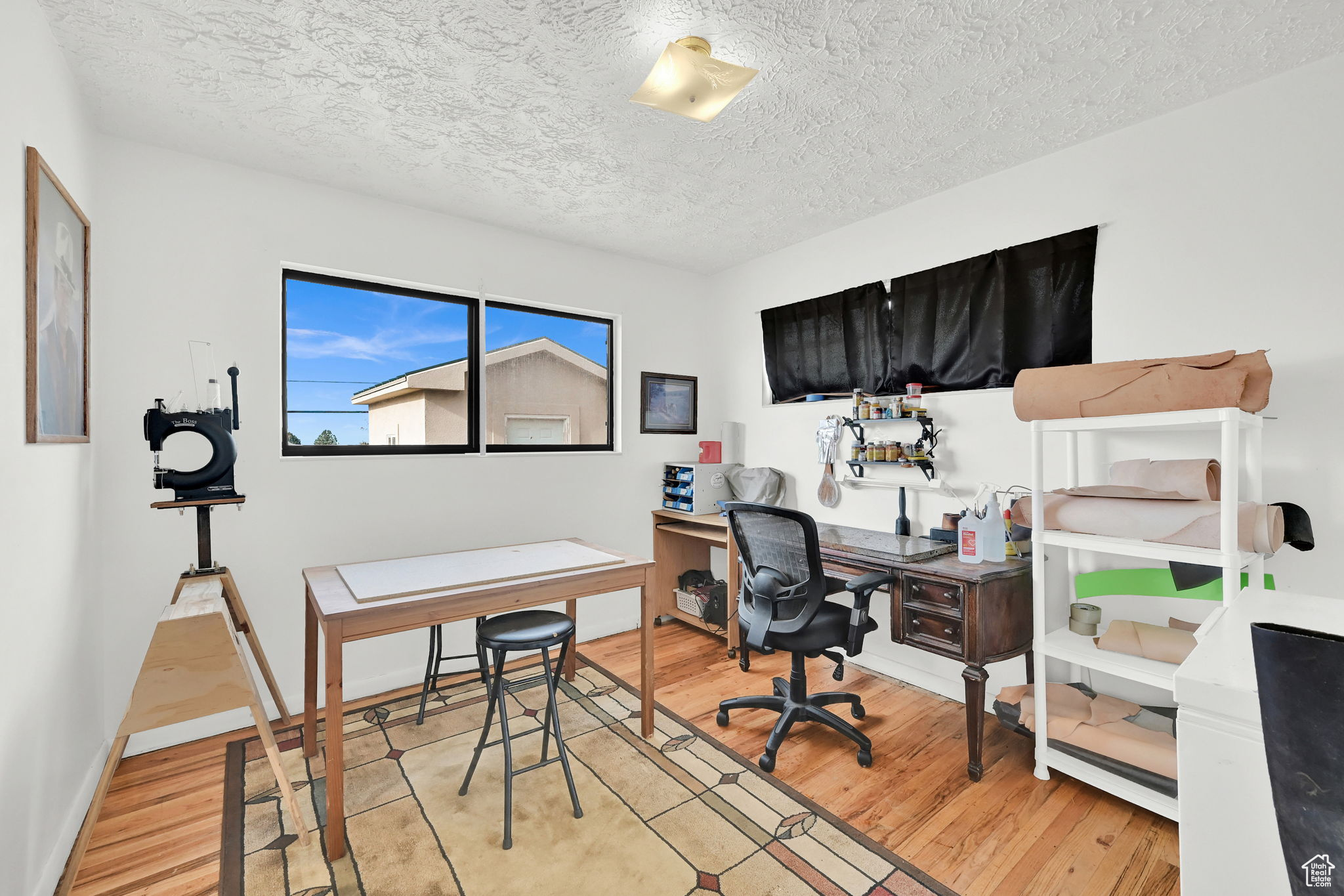 Office space with a textured ceiling and light wood-type flooring