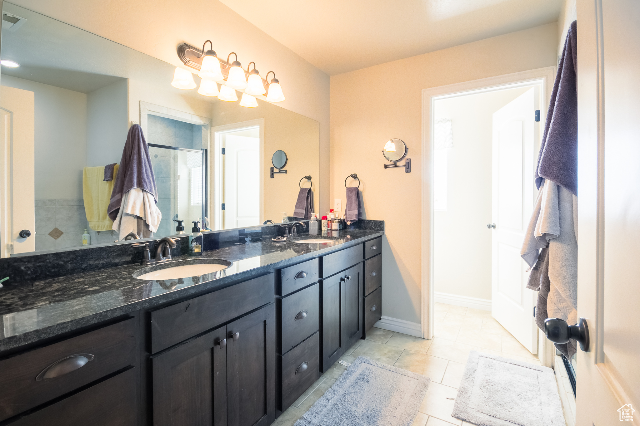 Master Bathroom with tile patterned floors, vanity, and a shower with shower door