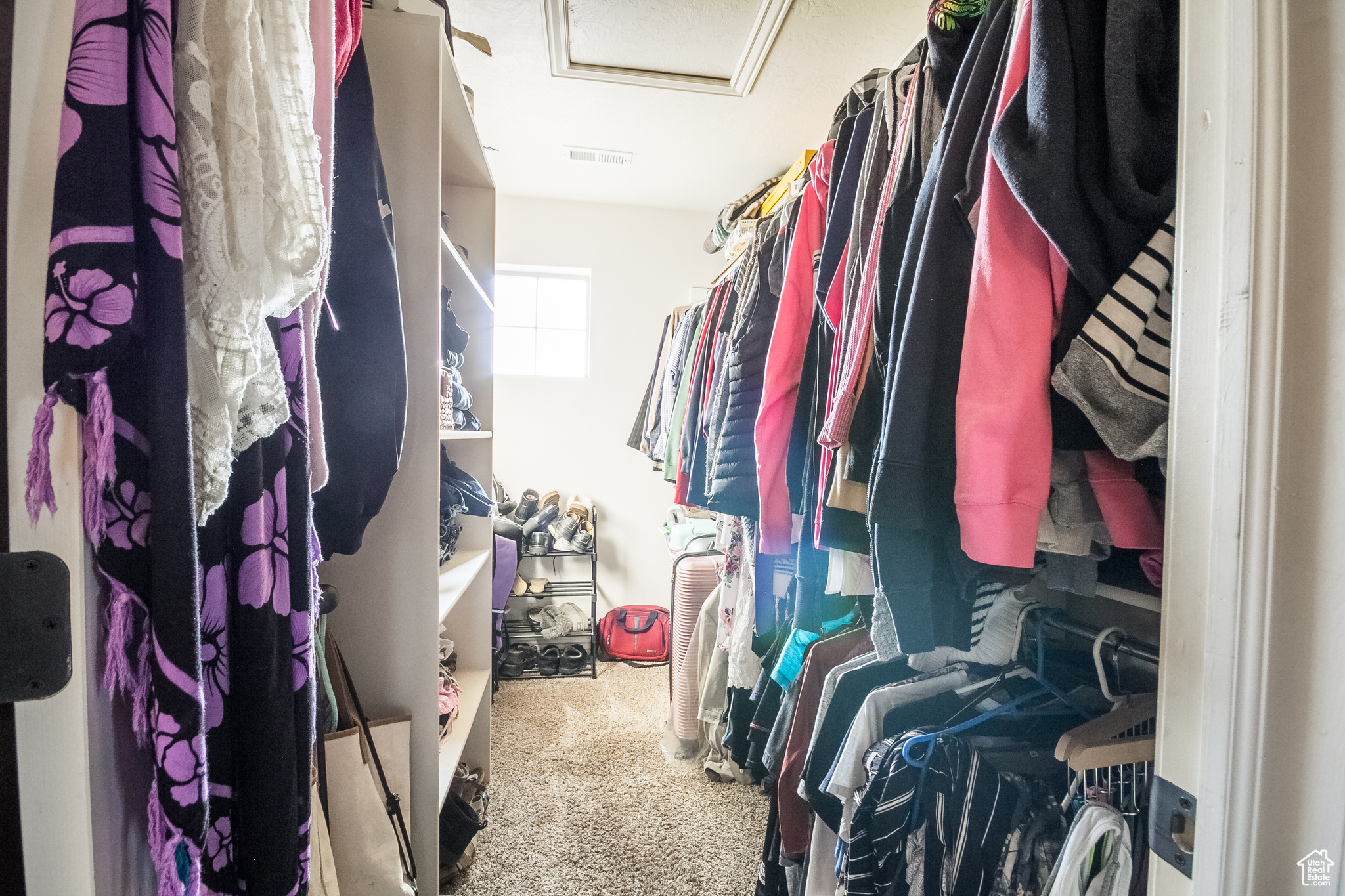 Spacious master bedroom closet with carpet flooring