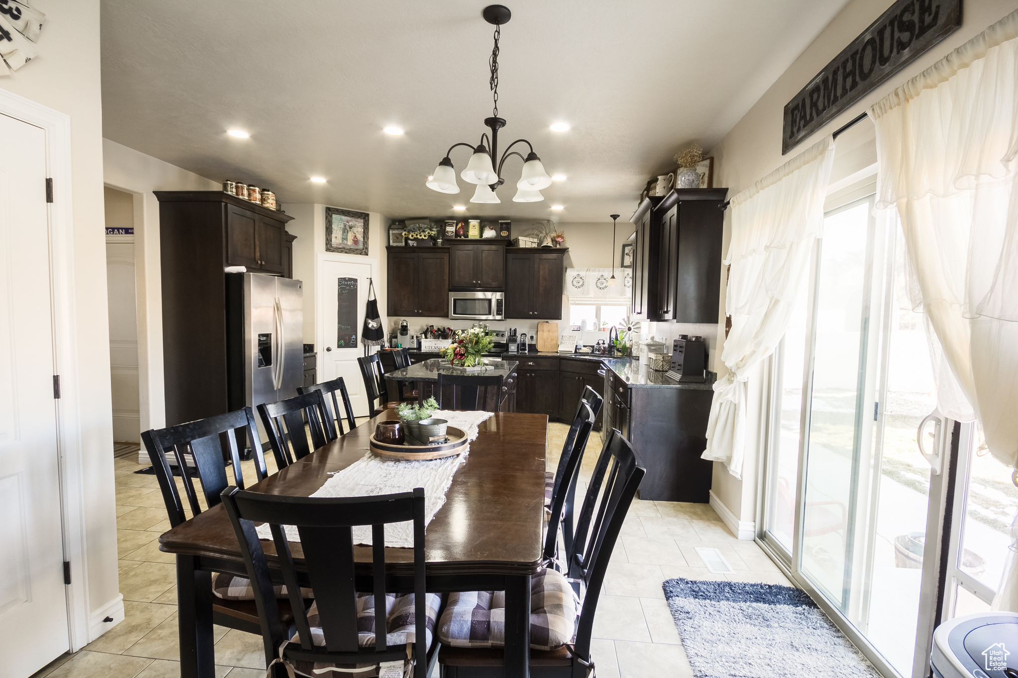 Dining space with a notable chandelier, light tile patterned flooring, and sink