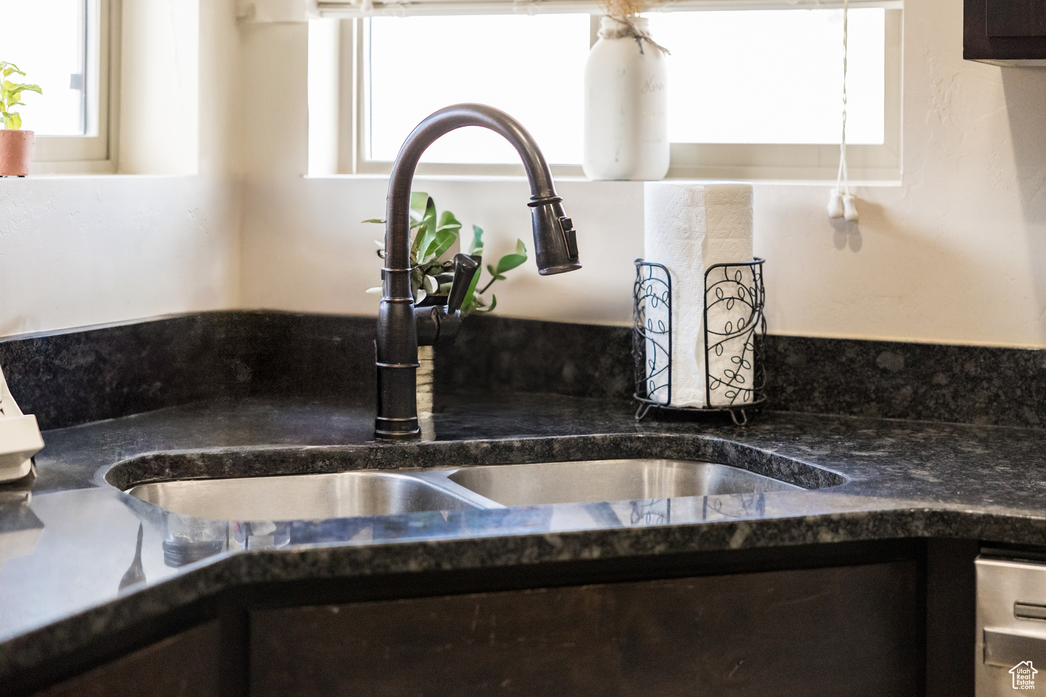 Room details with dark stone countertops, sink, and dark brown cabinets