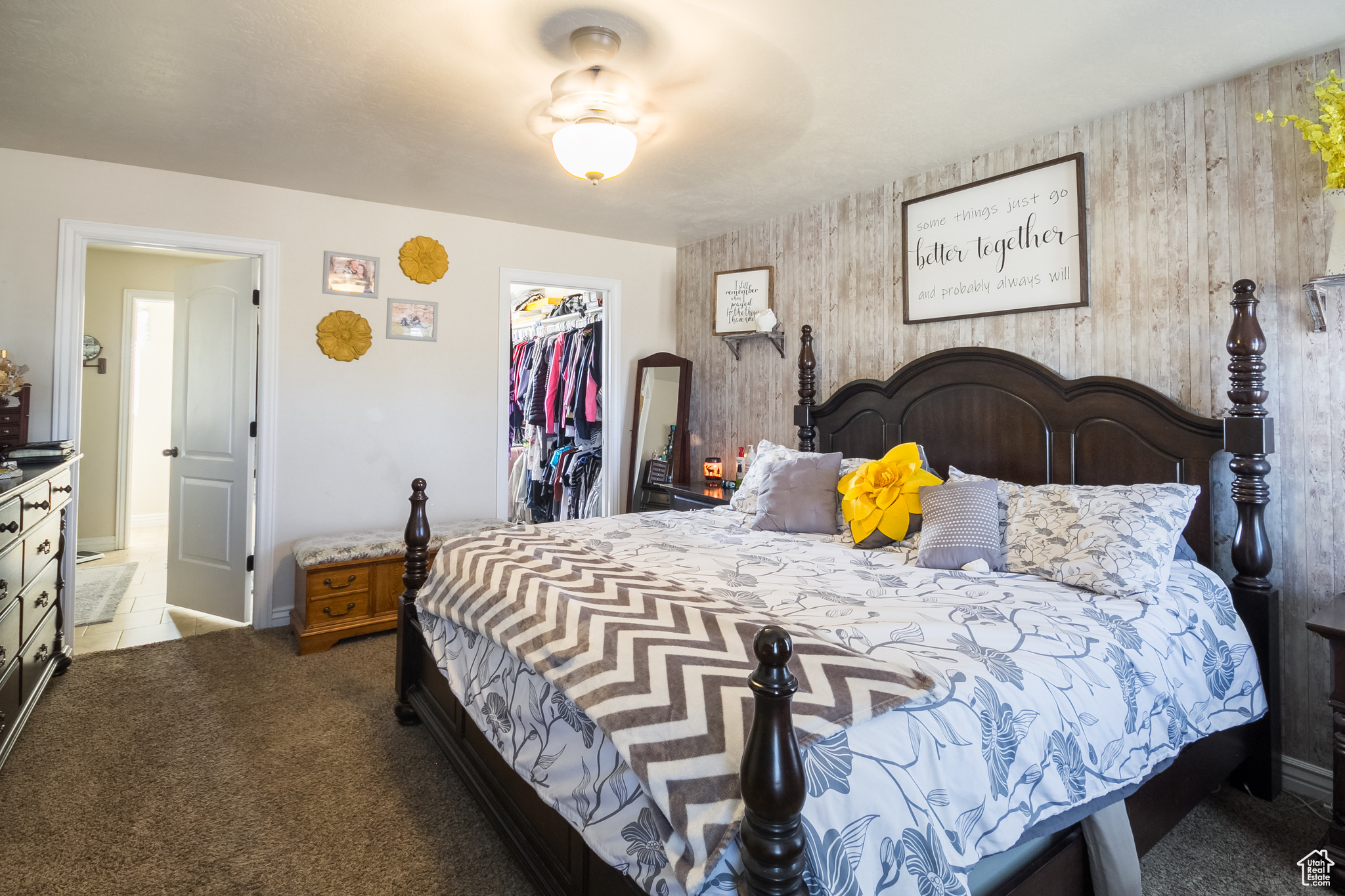 Master Bedroom with carpet flooring, a spacious closet, a closet, and wooden walls