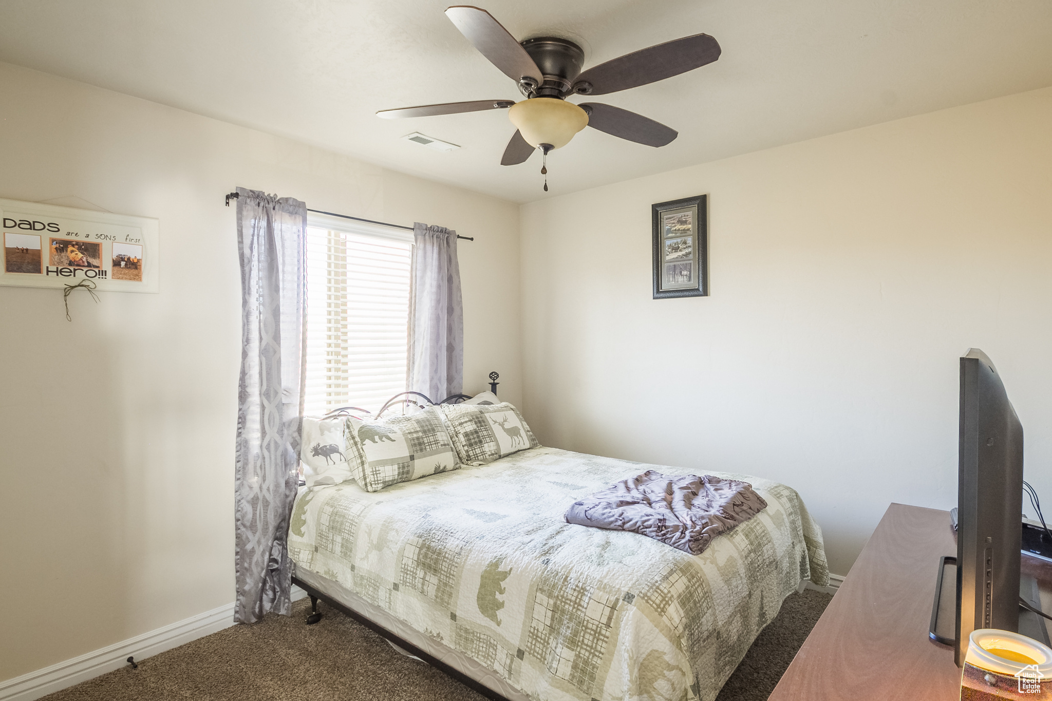 Spare bedroom 1of 2 with carpet floors and ceiling fan