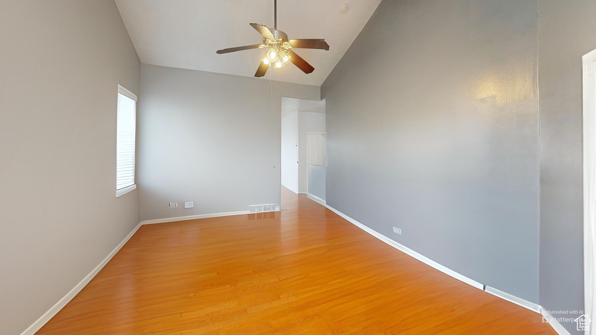 Virtually Un-staged room featuring lofted ceiling, ceiling fan, and wood-type flooring