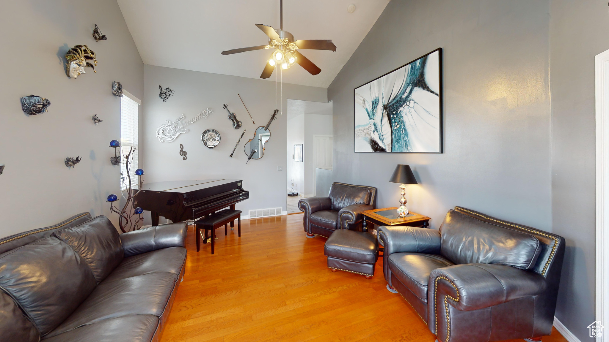 Living room with ceiling fan, wood-type flooring, and vaulted ceiling