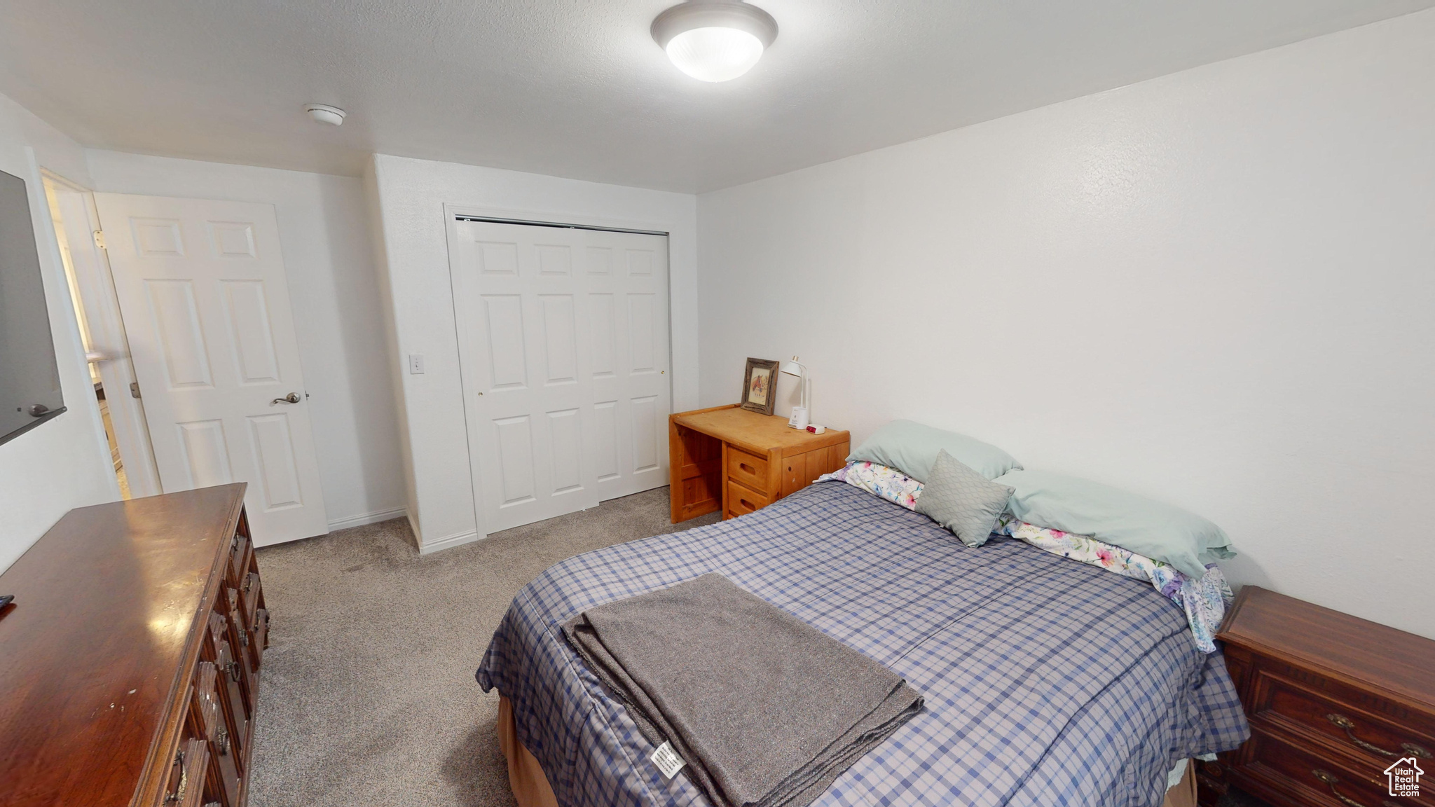 Bedroom featuring light colored carpet and a closet