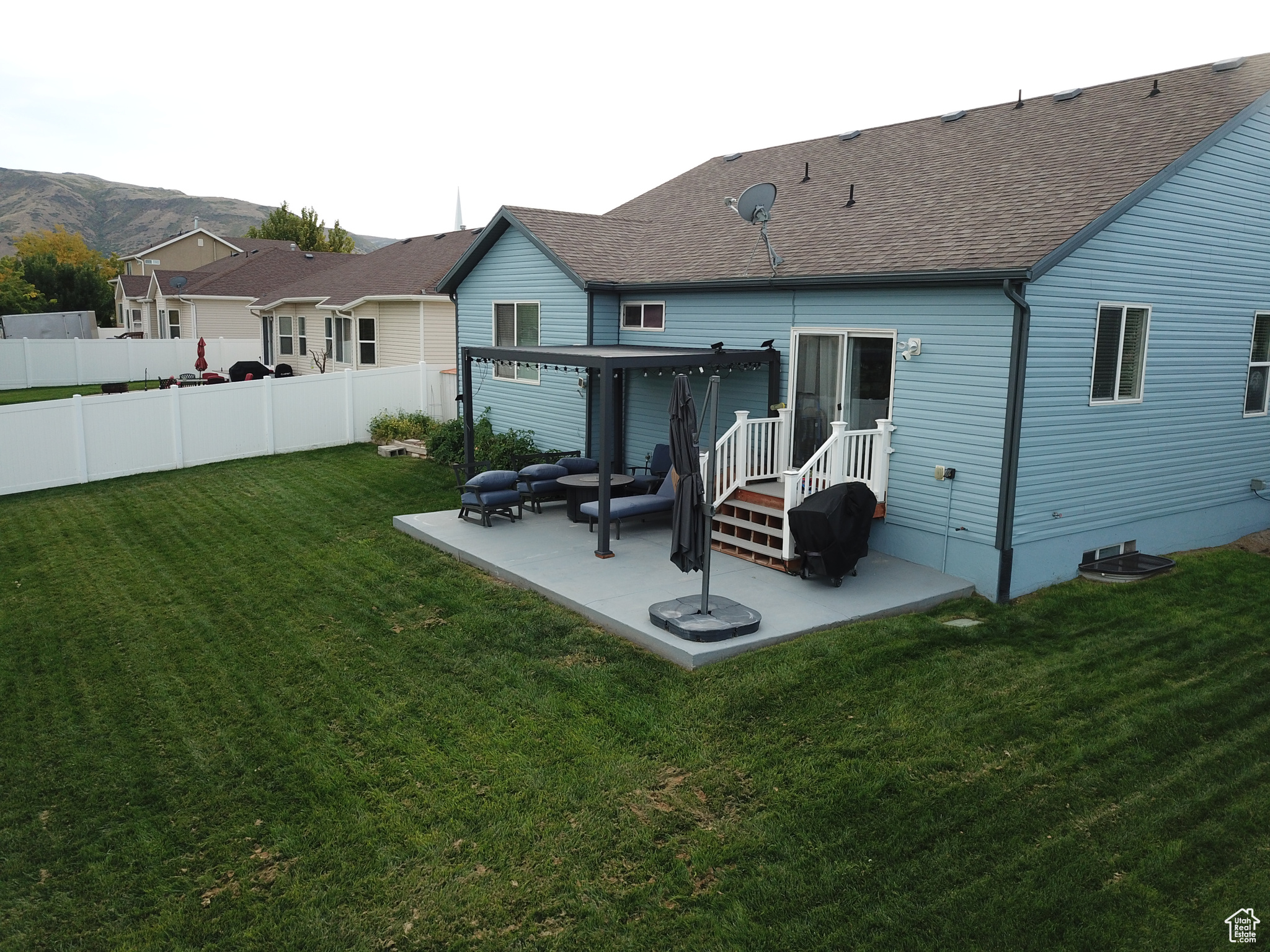 Rear view of house featuring a mountain view, a patio area, and a yard