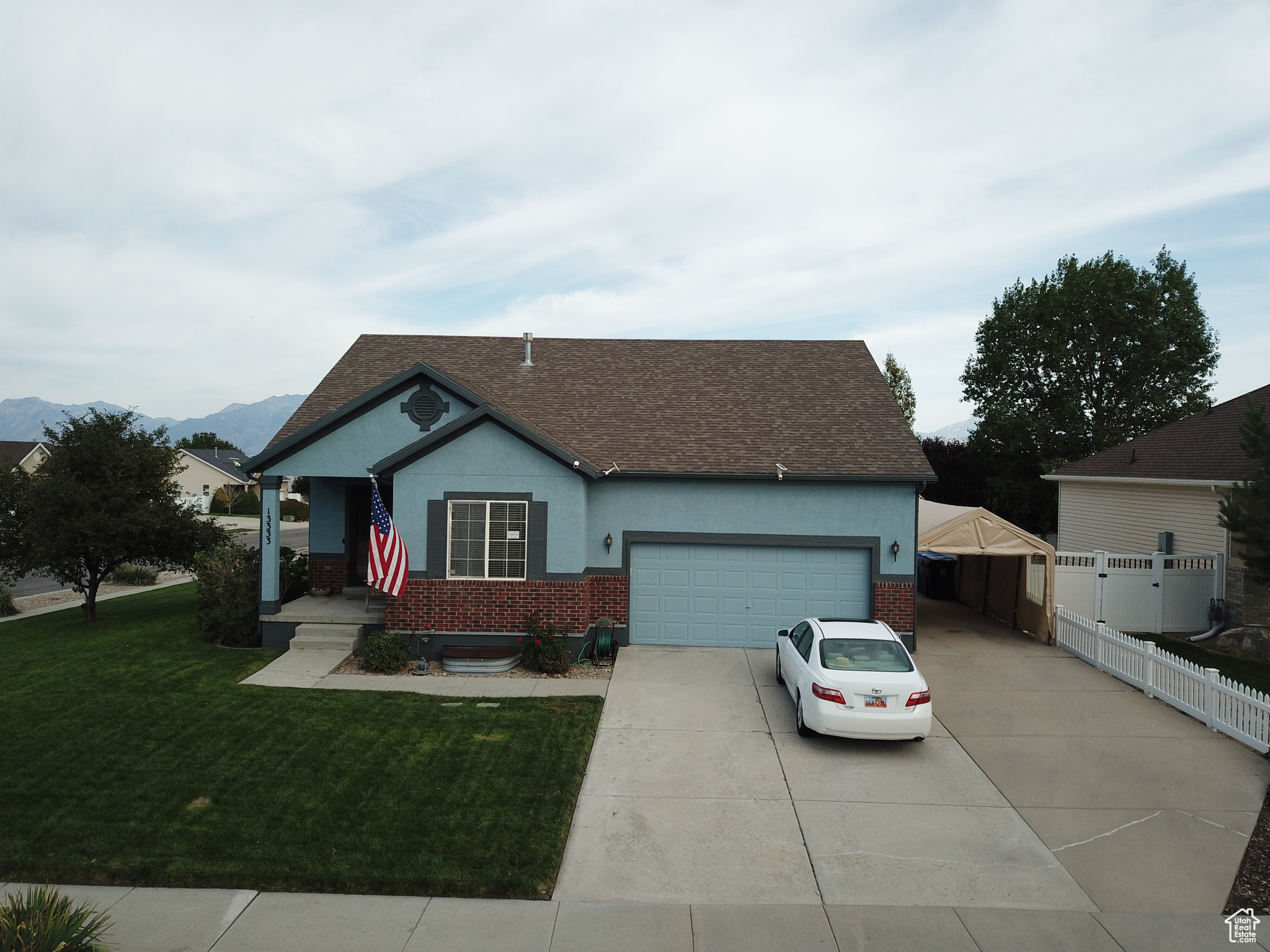 Ranch-style house with a mountain view, a garage, and a front lawn