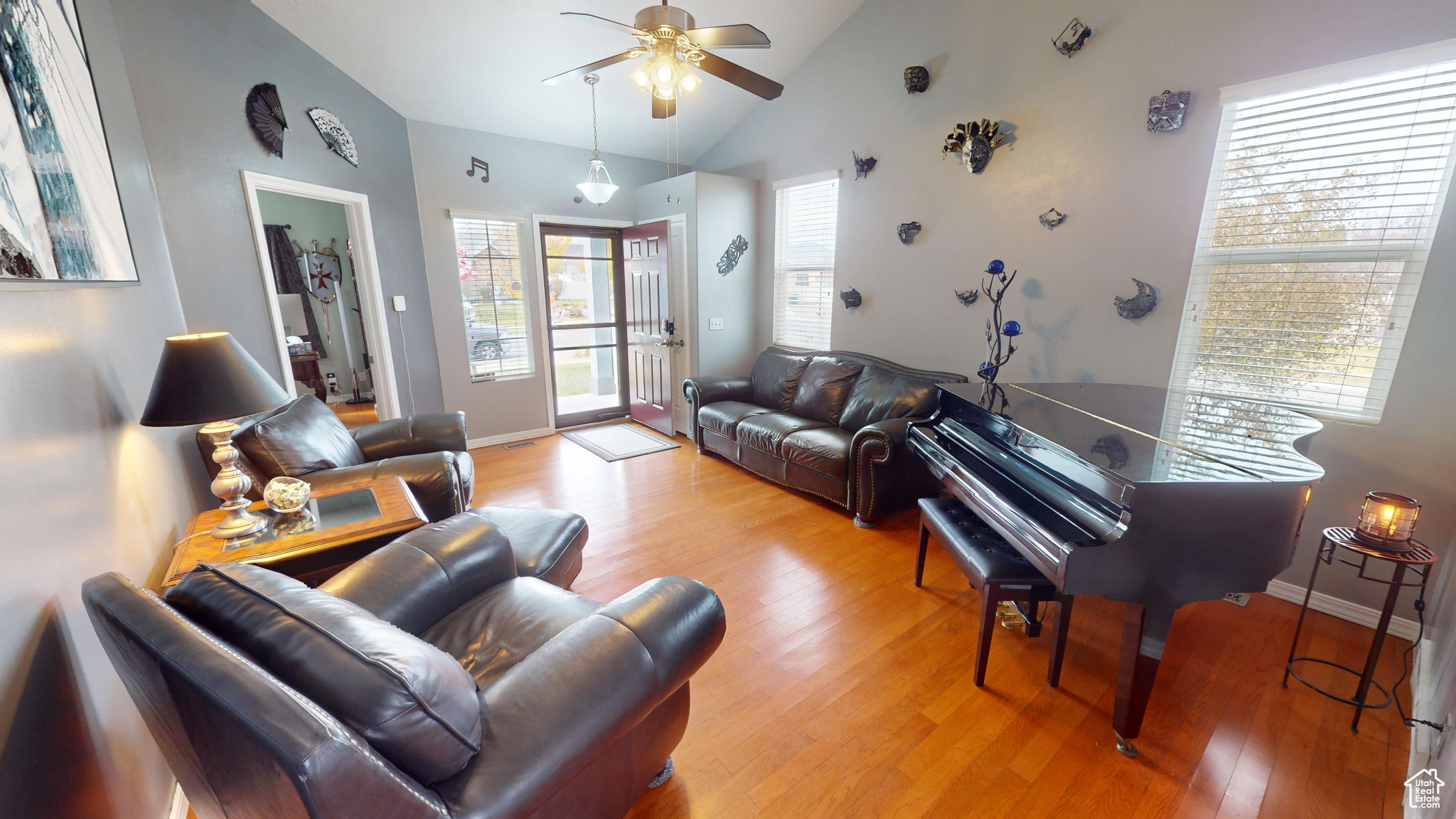 Living room featuring ceiling fan, light hardwood / wood-style floors, and lofted ceiling