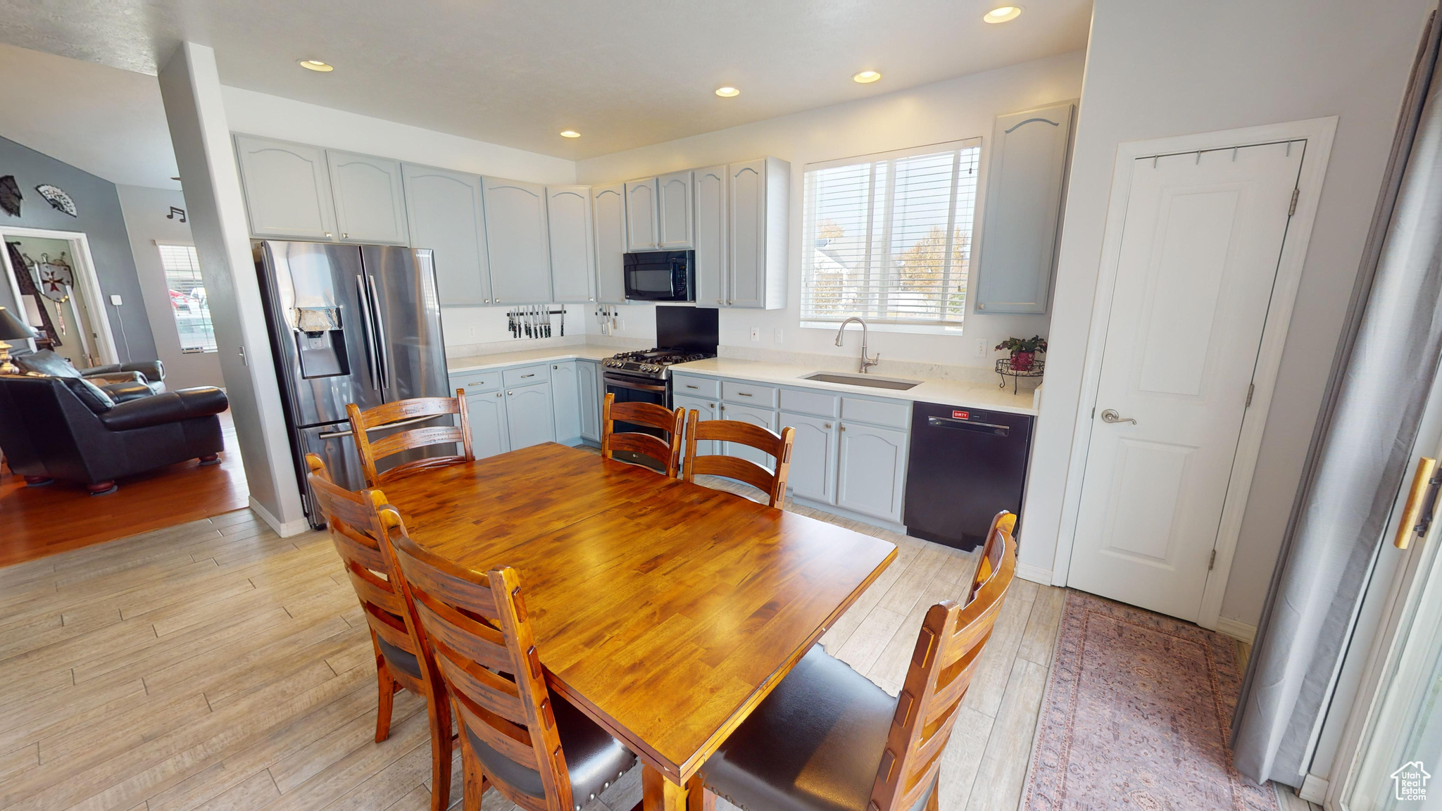 Kitchen featuring sink, black appliances, and light hardwood / wood-style floors