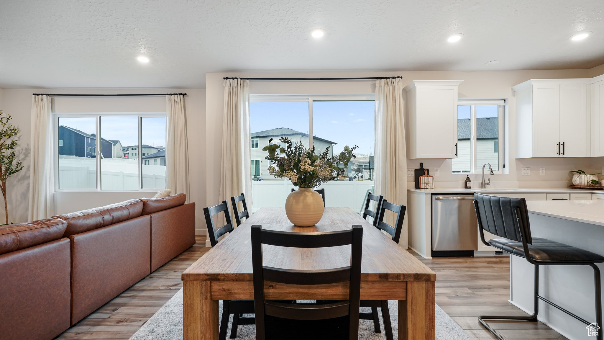 Dining room with a textured ceiling, light hardwood / wood-style flooring, and sink