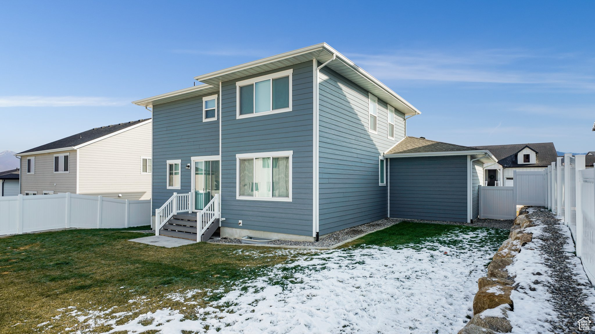 Snow covered property with a lawn