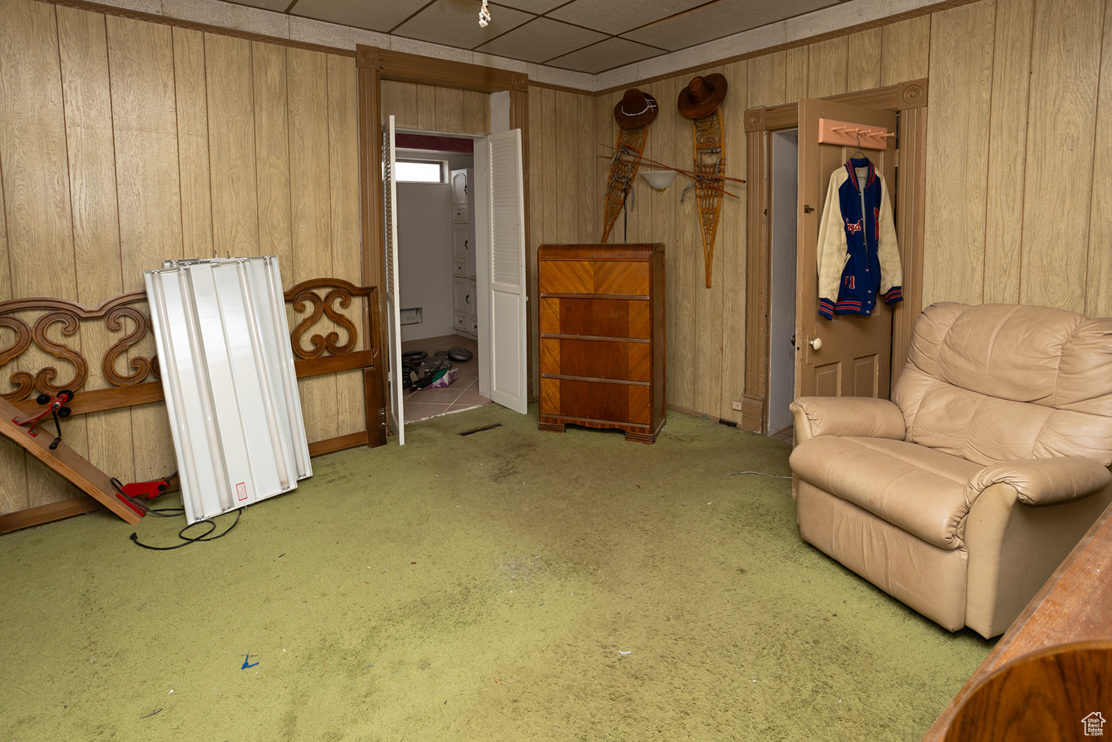 Living area with light colored carpet and wooden walls