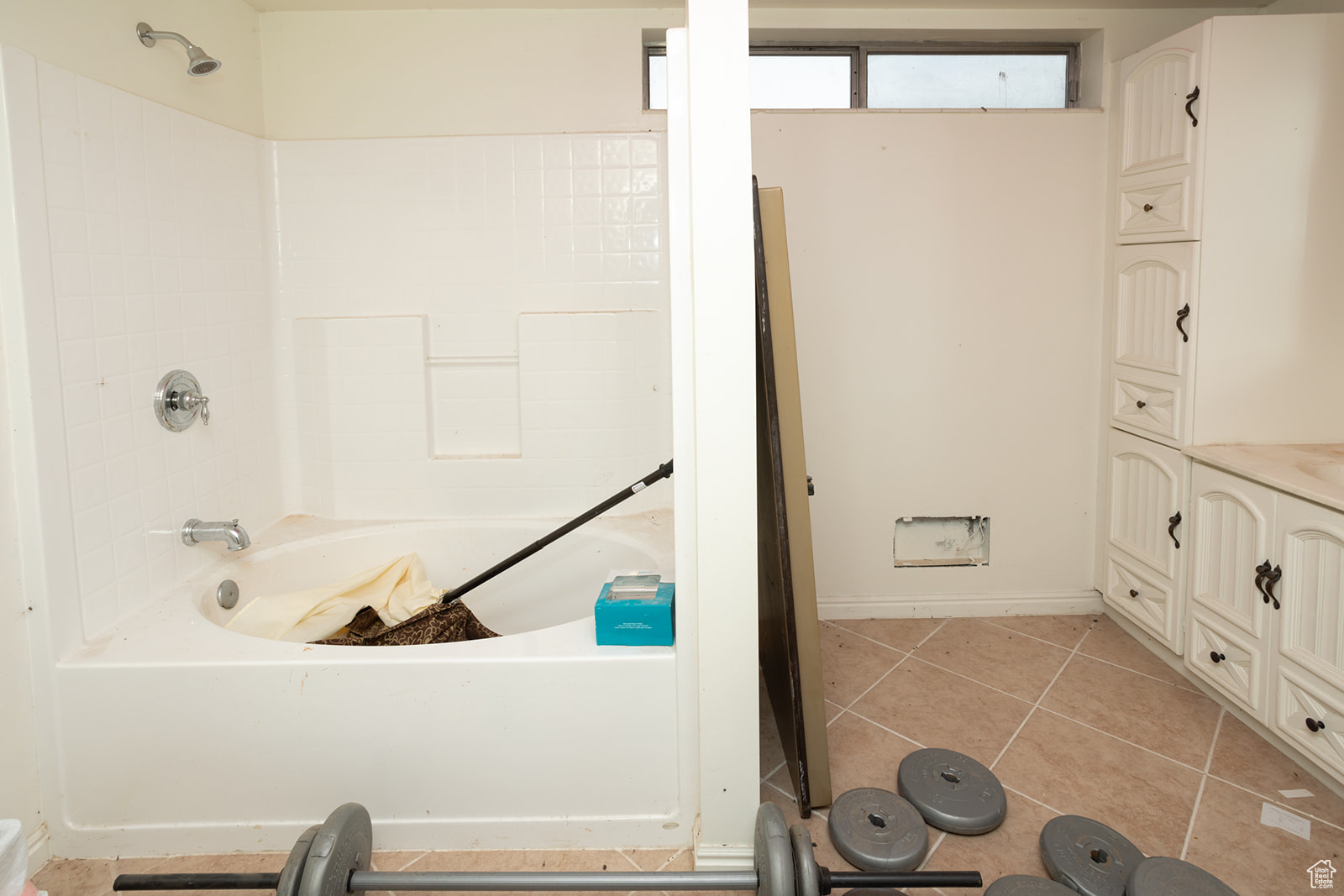 Bathroom featuring tile patterned floors, vanity, and a bath