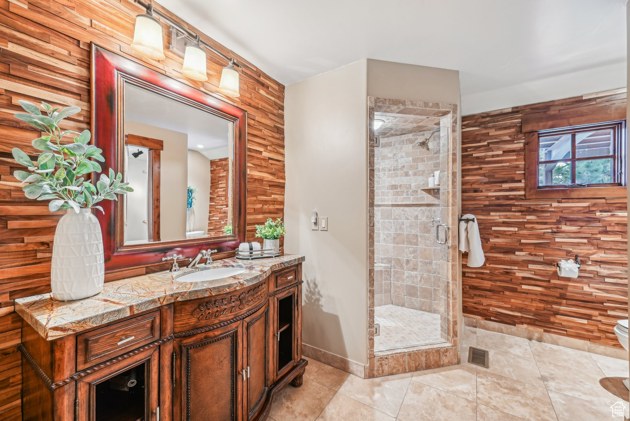 Bathroom with walk in shower, vanity, tile patterned flooring, toilet, and wood walls