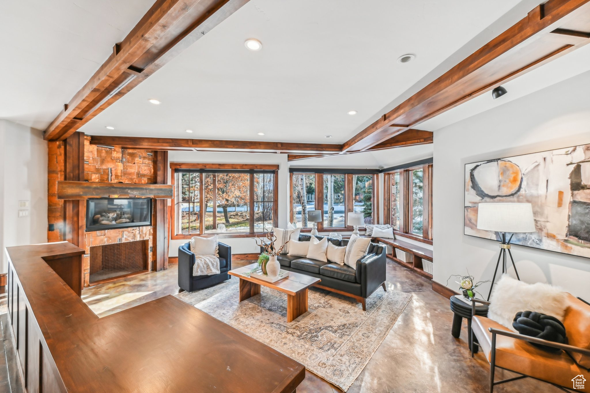 Living room with beam ceiling and a stone fireplace