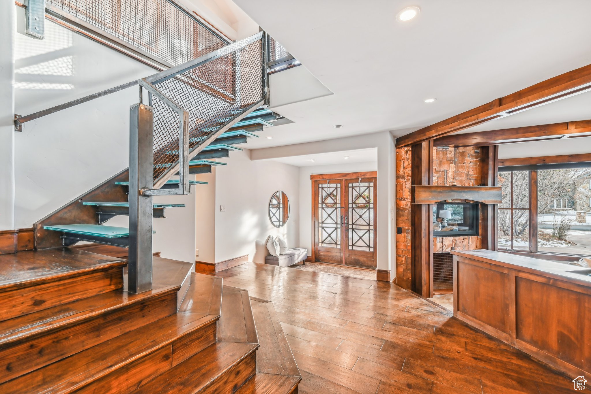 Stairway with hardwood / wood-style flooring and a stone fireplace