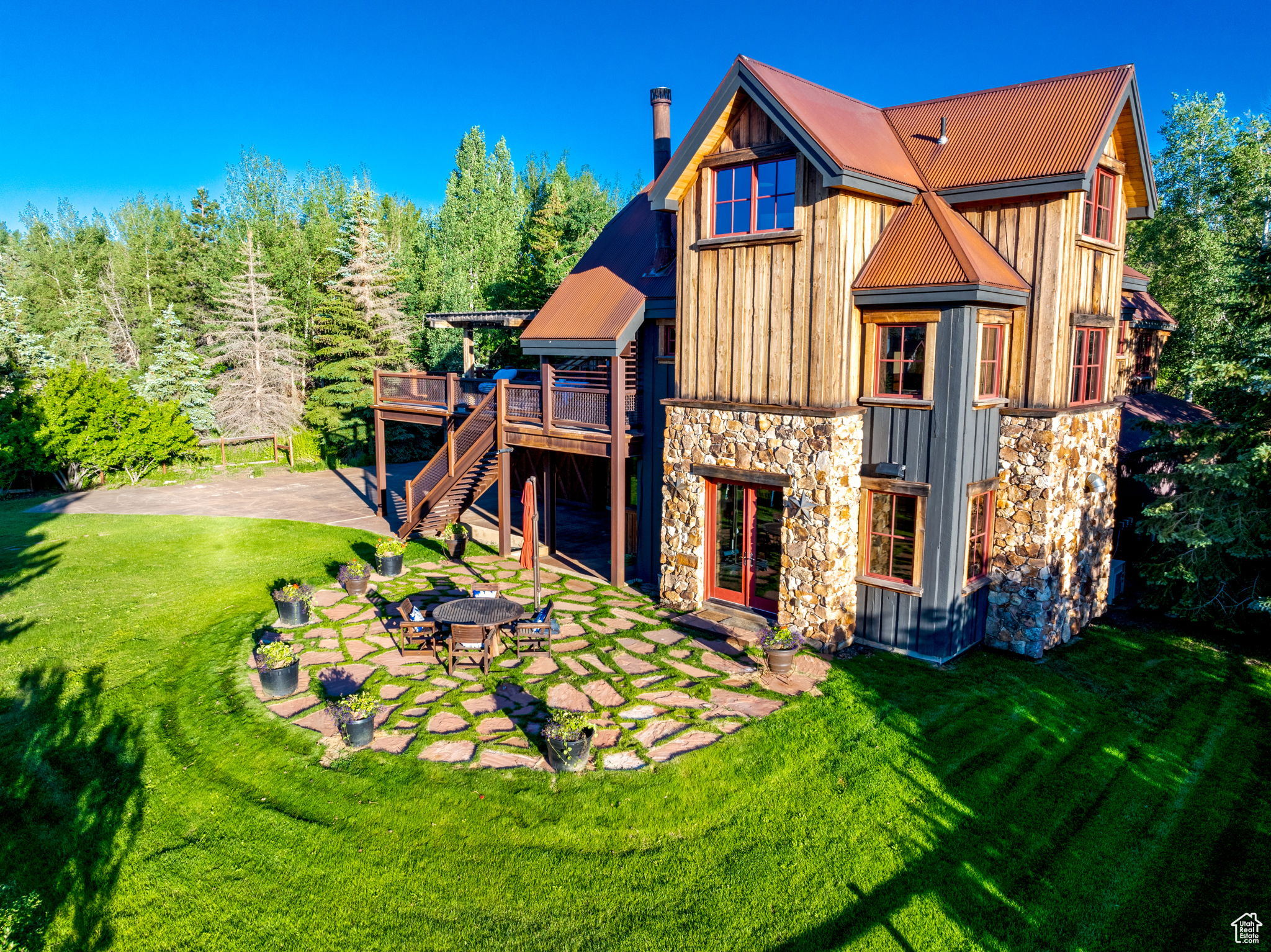 Rear view of house featuring a fire pit, a patio area, a yard, and a wooden deck