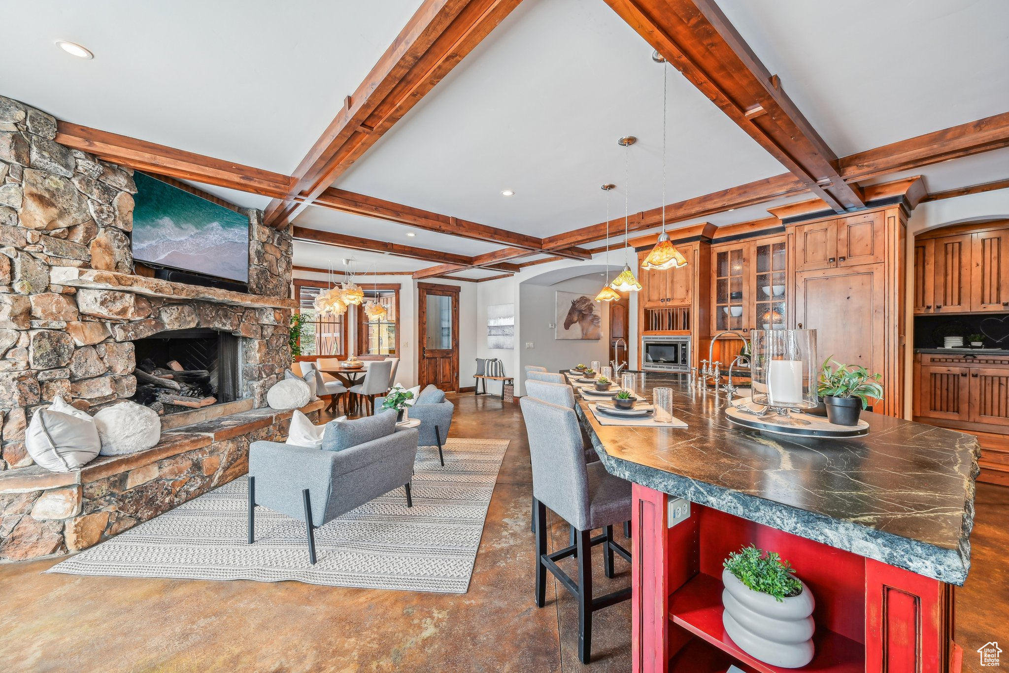 Living room featuring beamed ceiling, an inviting chandelier, a fireplace, and coffered ceiling